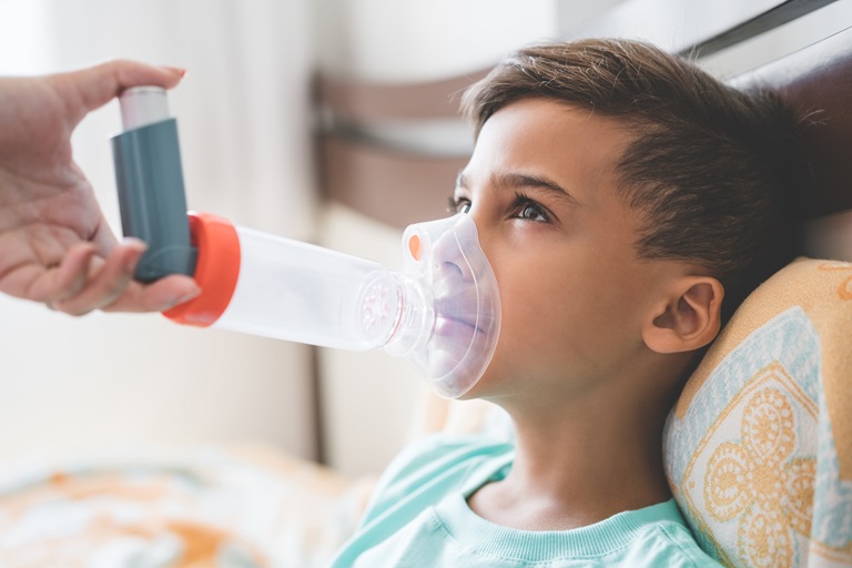 Woman with son doing inhalation with nebulizer at home
