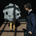 a man walking by a person dressed up as a giant polio virus