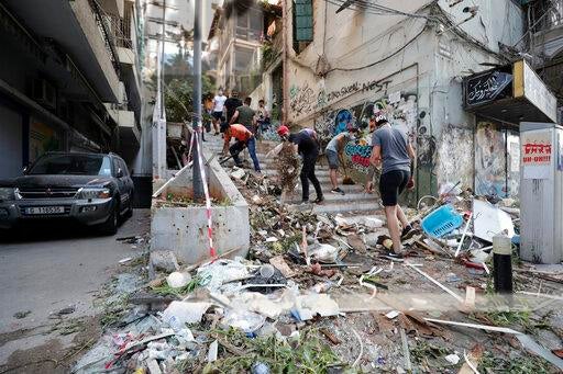 People clean up after a massive explosion in Beirut, Lebanon