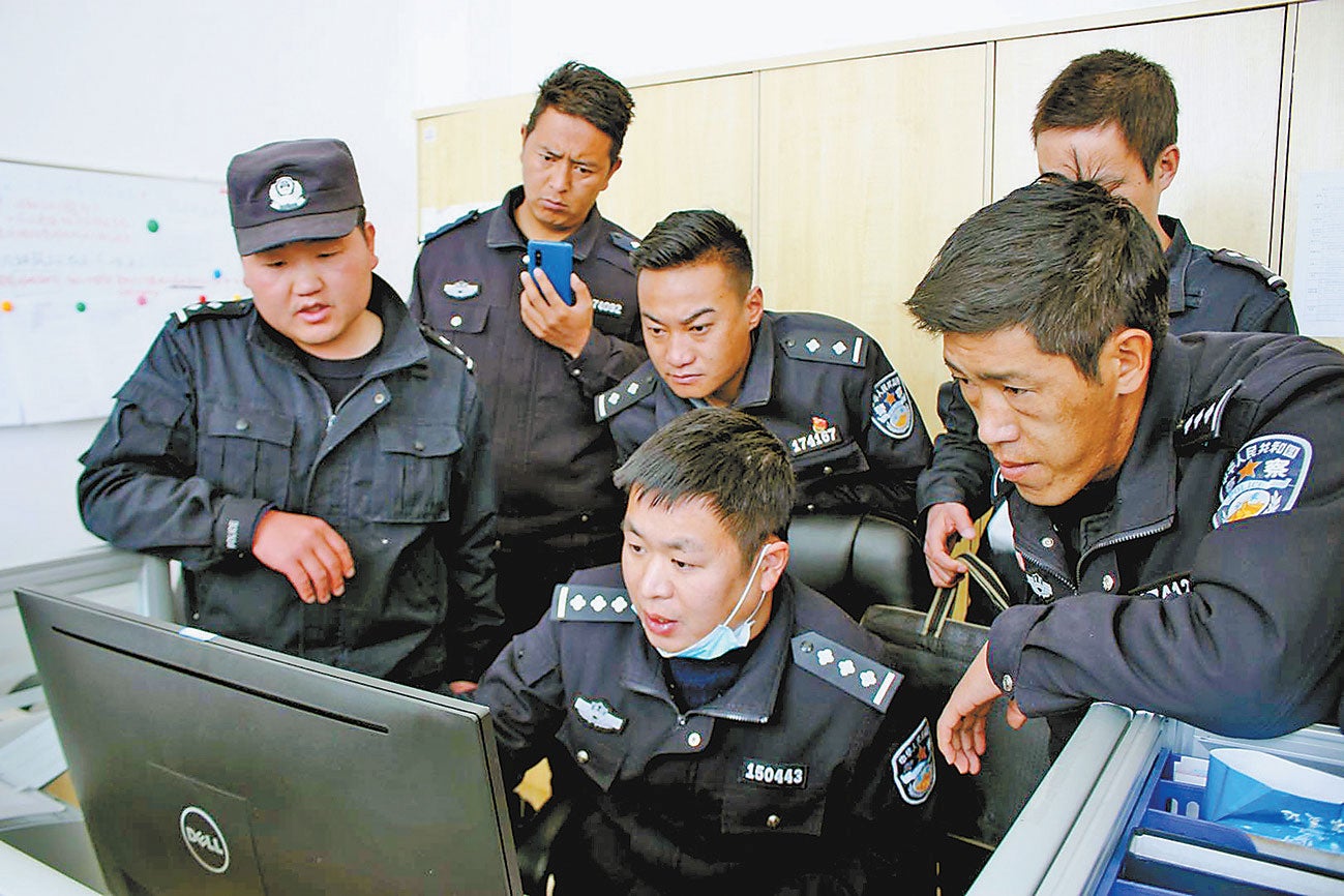People’s Police at the new Fengqiao-style police post in Chushul County, Lhasa Municipality, Tibet Autonomous Region, discussing their work.