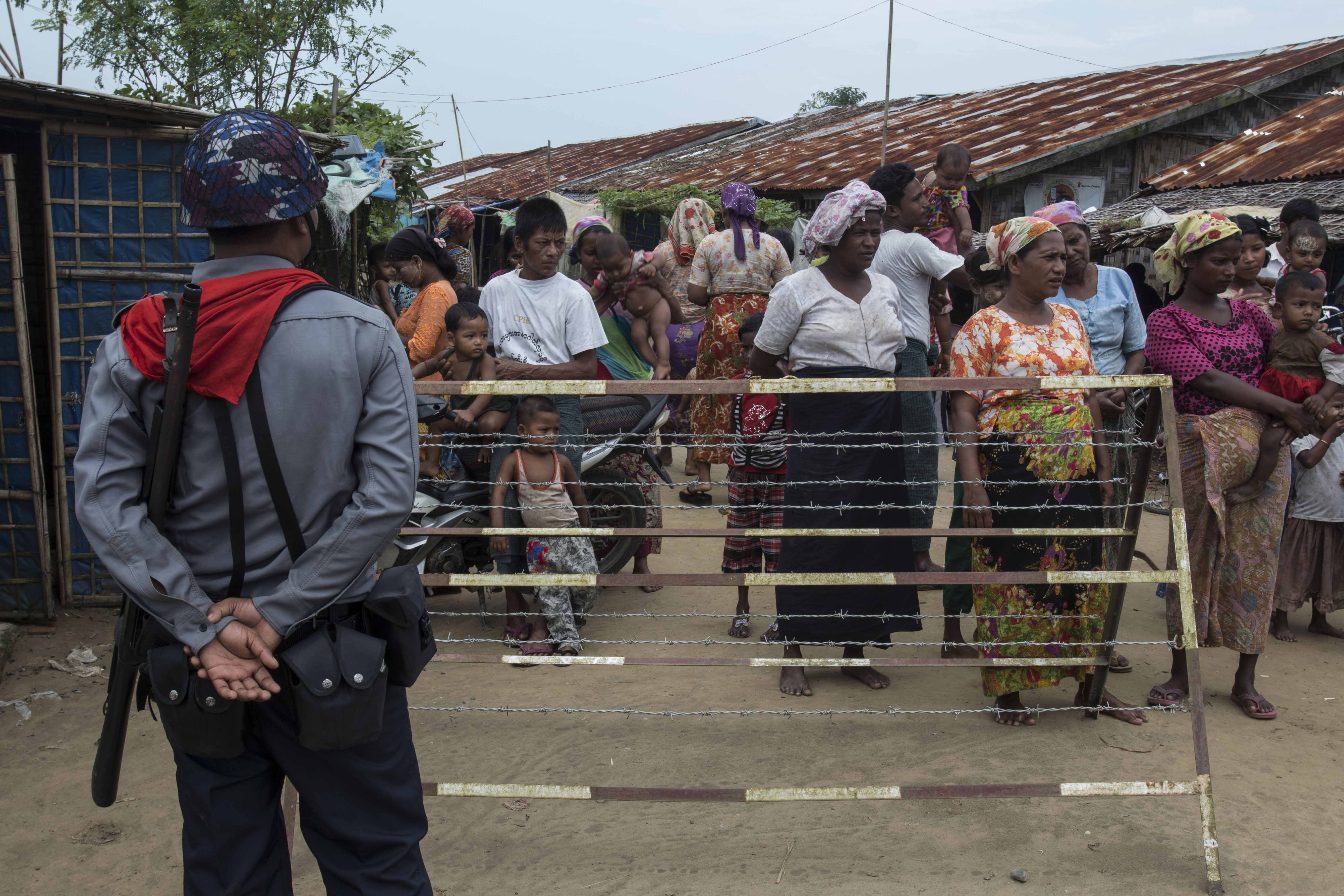 A Myanmar police officer patrols a camp.