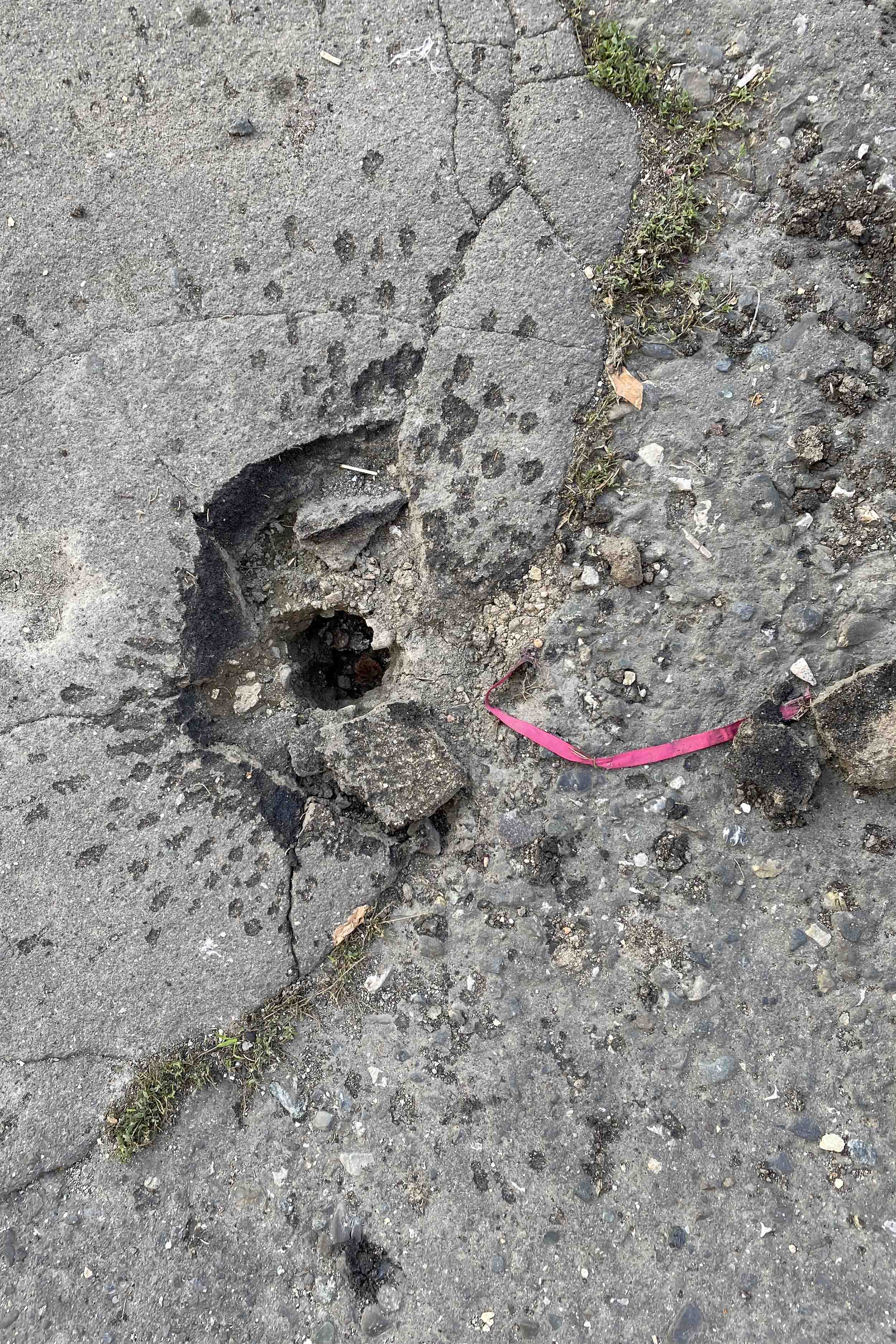 Характерные следы разрыва суббоеприпаса М095 и розовая стабилизационная лента рядом со зданием Карабах Телекома в Степанакерте 