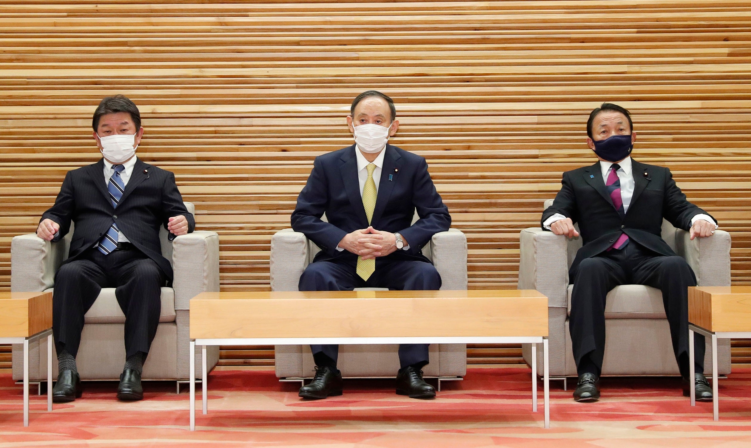 Japanese Foreign Minister Toshimitsu Motegi (left), Prime Minister Yoshihide Suga (center), and Finance Minister Taro Aso (right) attend a Cabinet meeting in Tokyo on February 24, 2021.
