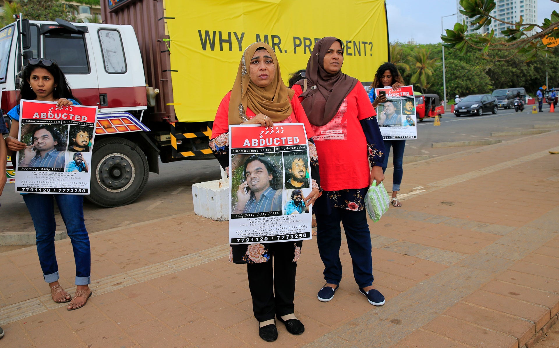 Relatives of disappeared Maldivian journalist Ahmed Rilwan Abdulla hold a silent protest during International Day of the Victims of Enforced Disappearances, holding signs.