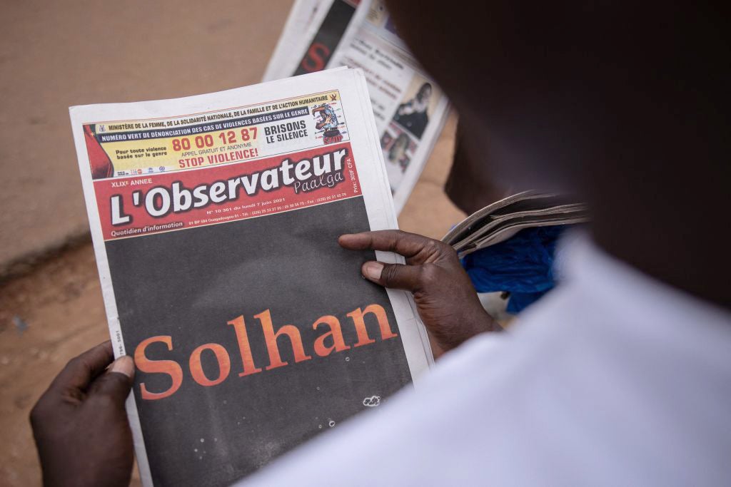 A man reads the L'Observateur Paalga newspaper in Ouagadougou on June 7, 2021, about the attacks that happened in Solhan. 