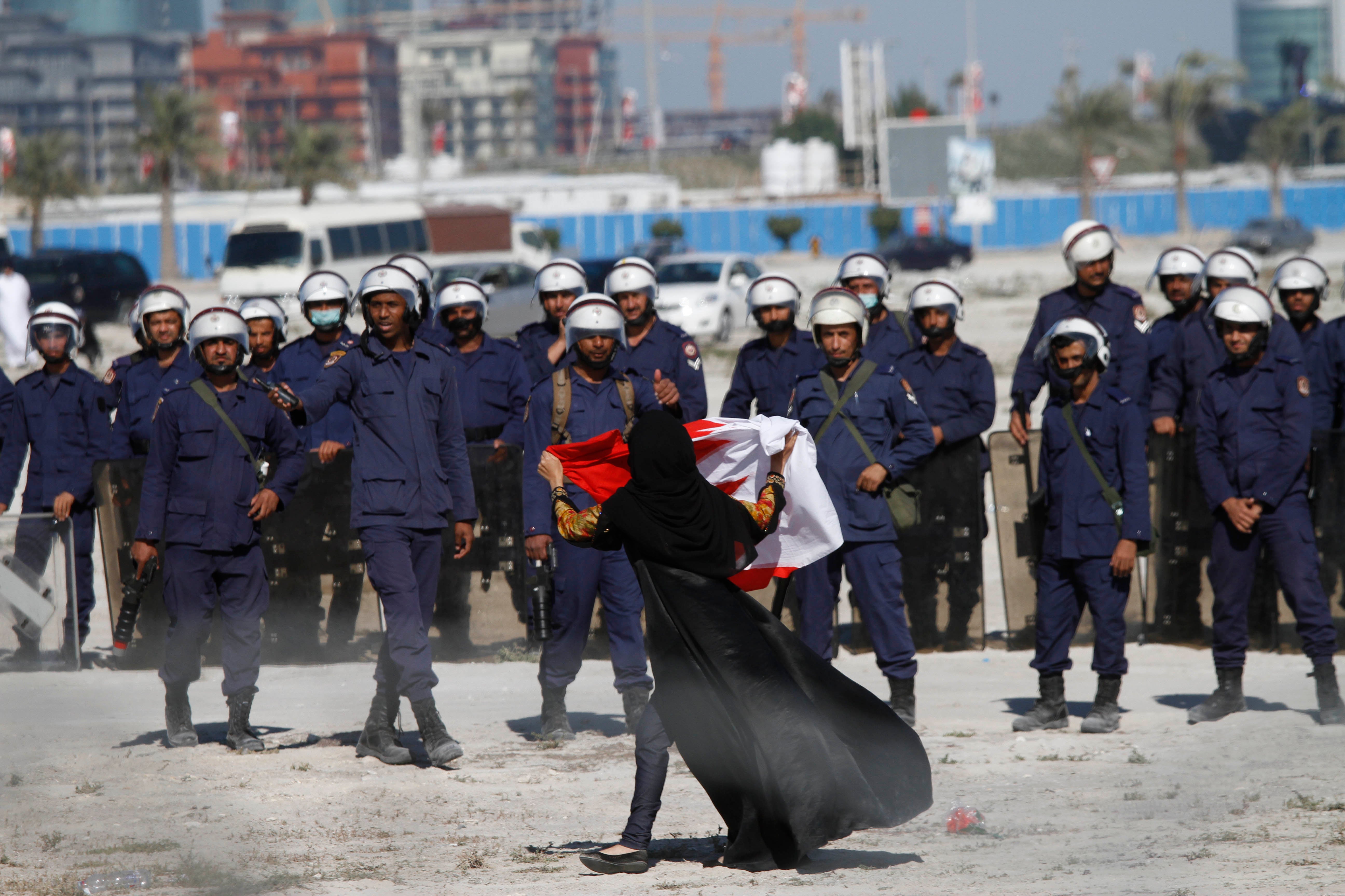 An anti-government protestor gestures in front of police as demonstrators re-occupy Pearl roundabout on February 19, 2011 in Manama, Bahrain. Ten years after the anti-government protests, virtually all opposition has been quashed.