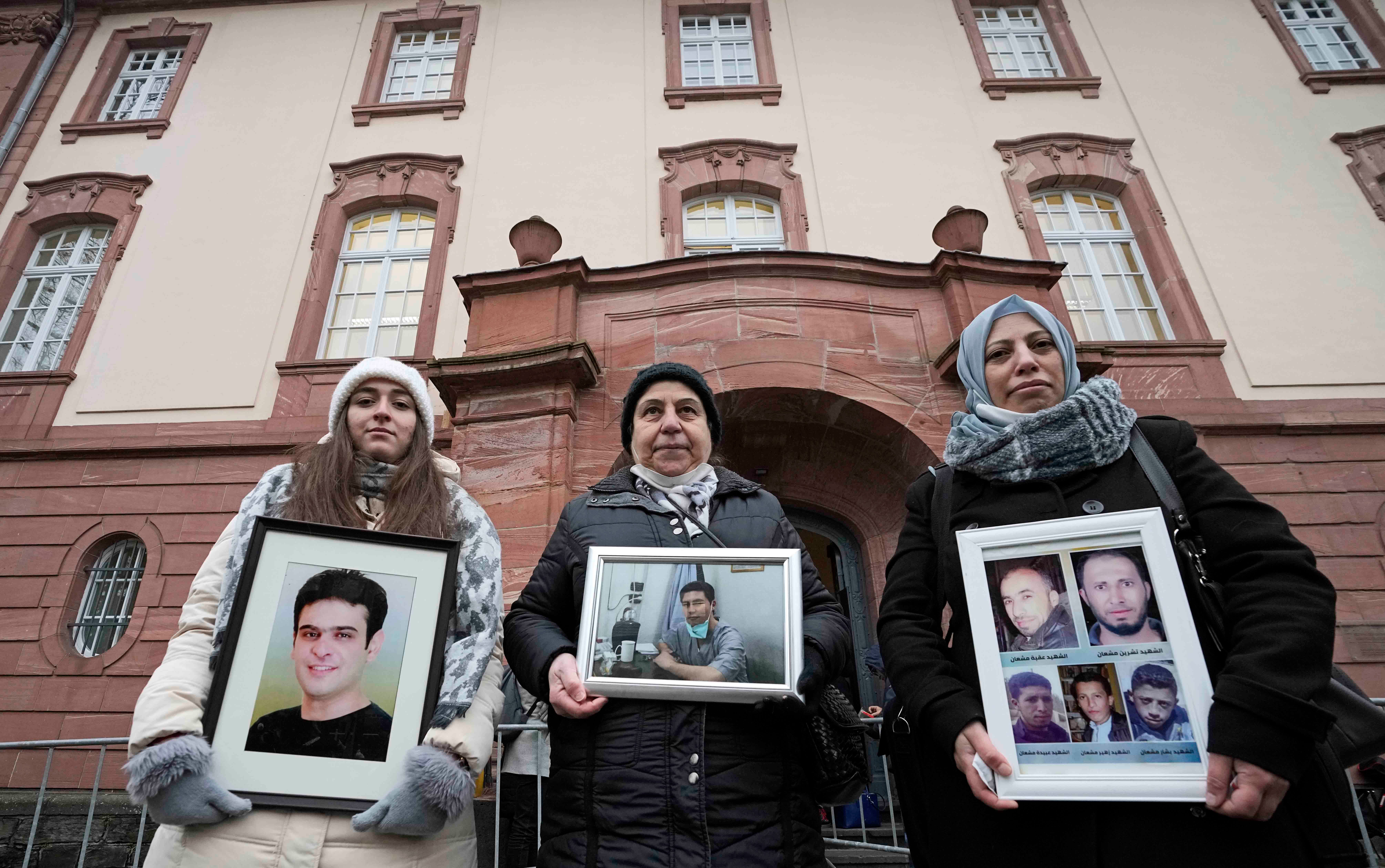 3 women hold framed photographs