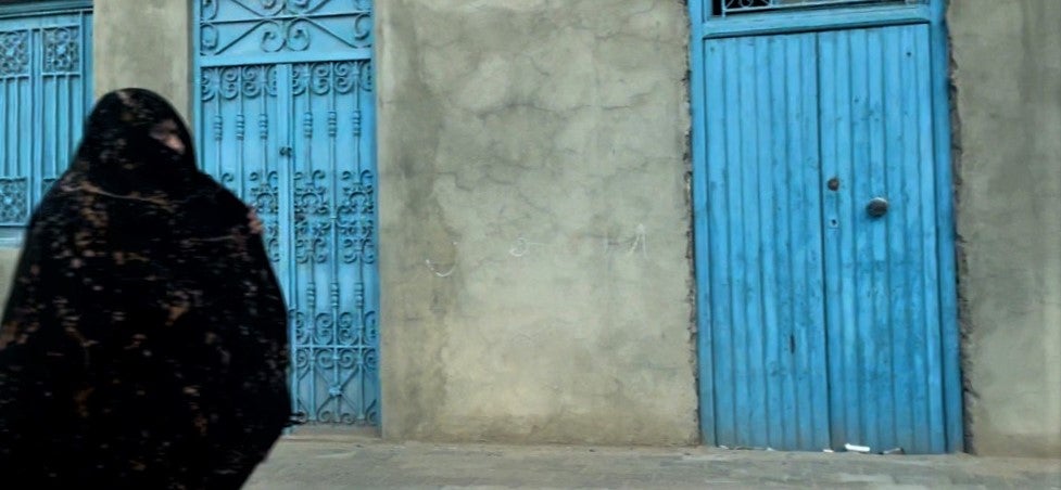A woman walking on the street in Zarziss, Tunisia.