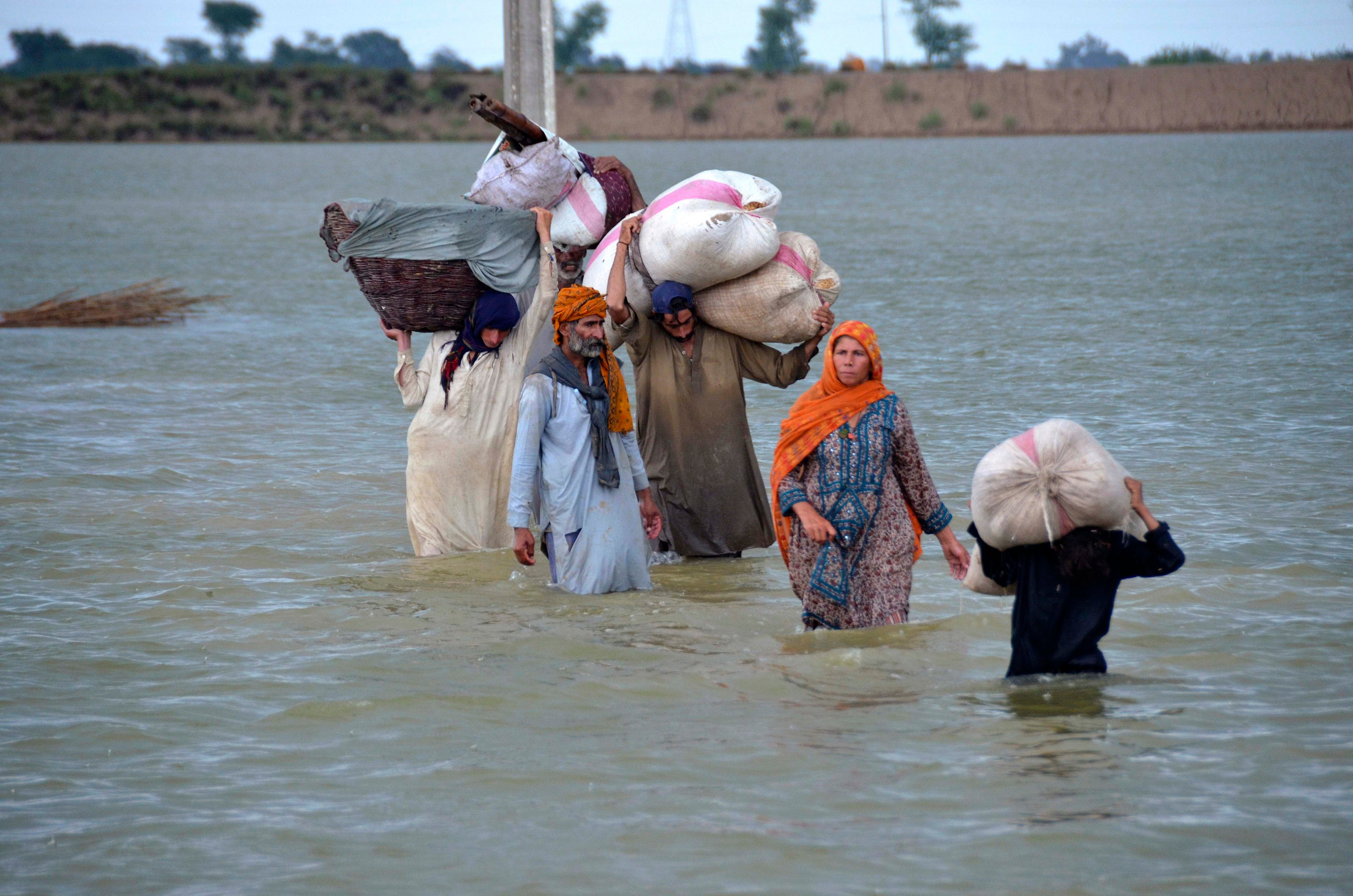 A displaced family wades through a flooded area after heavy rainfall in Jaffarabad, in Pakistan's southwestern Balochistan province.