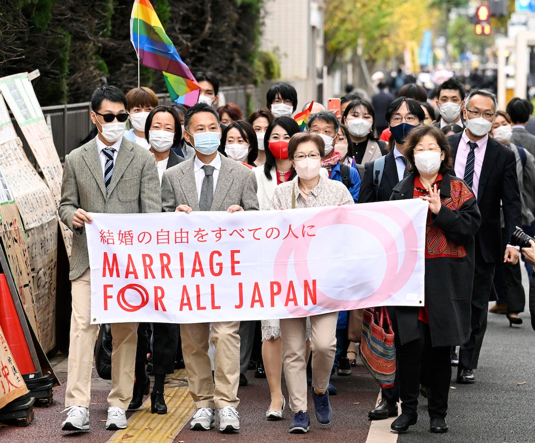 Plaintiffs and supporters of marriage equality for same sex couples walk to the Tokyo district court.