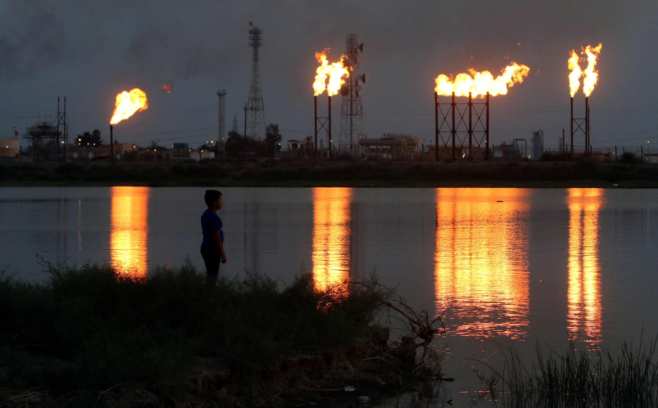 Flames emerge from flare stacks at Nahr Bin Umar oil field, north of Basra, Iraq.