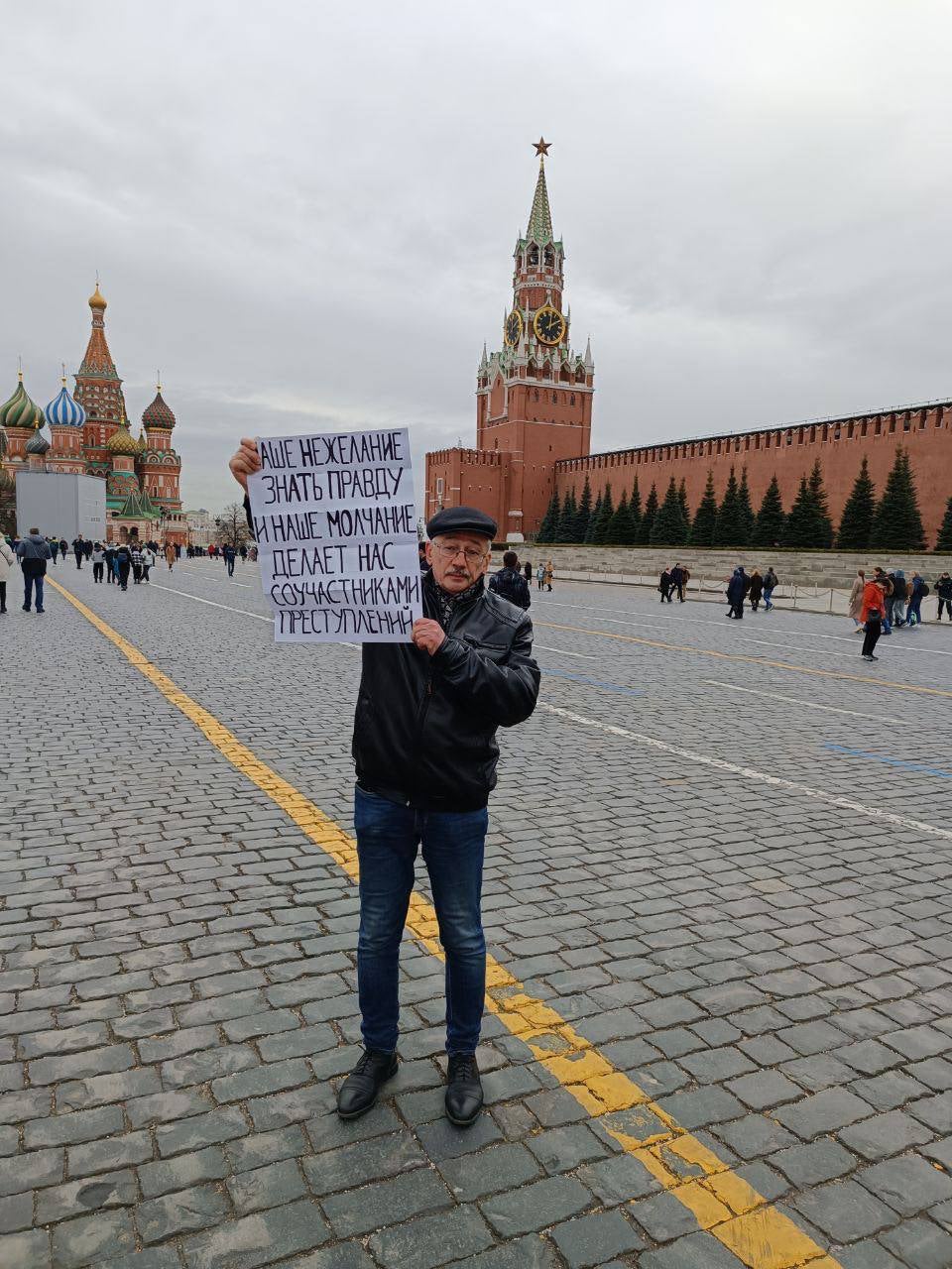 Oleg Orlov protesting Russia's abusive war in Ukraine at the Red Square in Moscow, April 2022. His poster reads, 'Our unwillingness to know the truth and our silence turn us into collaborators in crimes.’