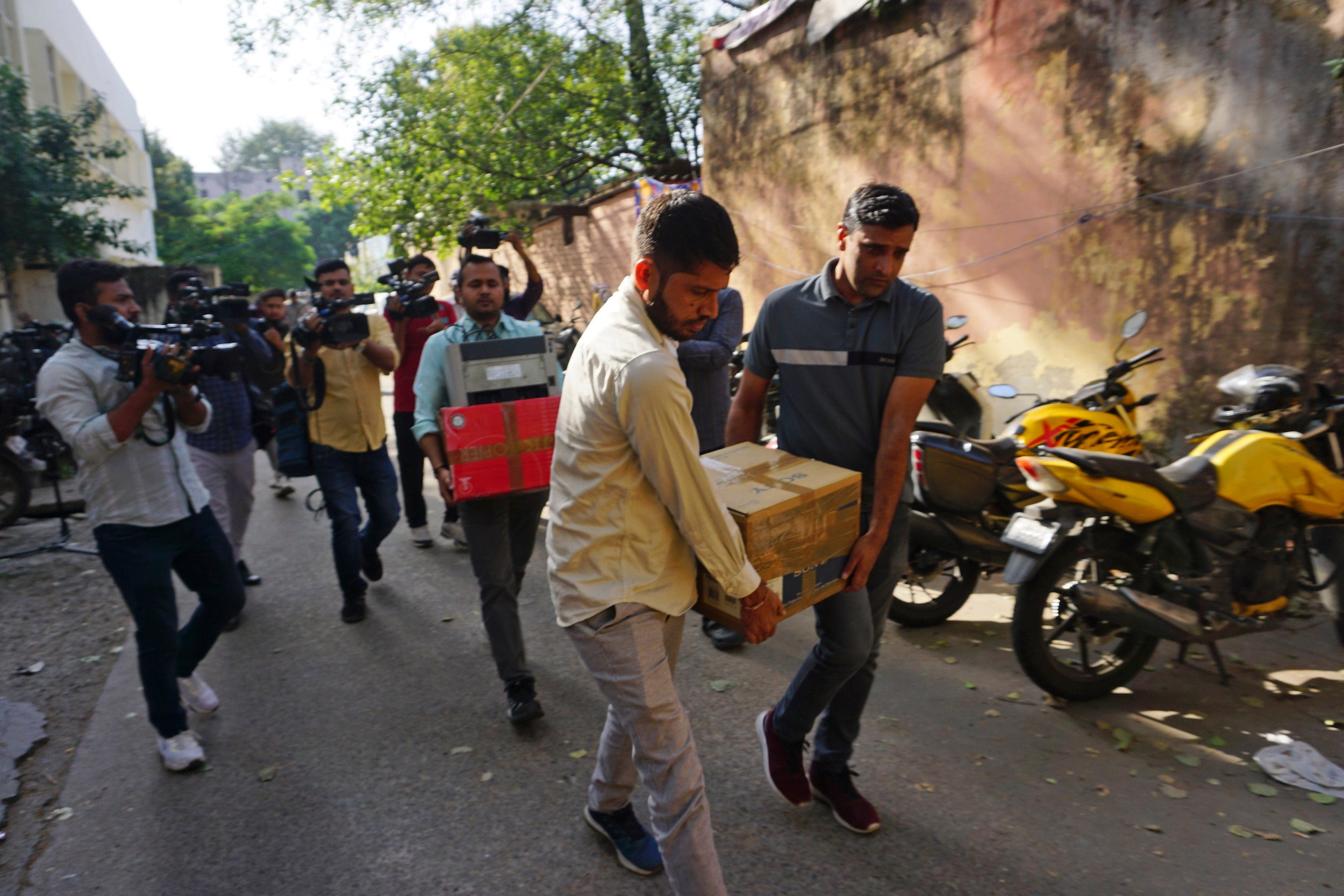 Security officers carry boxes of material confiscated after a raid at the office of NewsClick in New Delhi, India, October 3, 2023. 