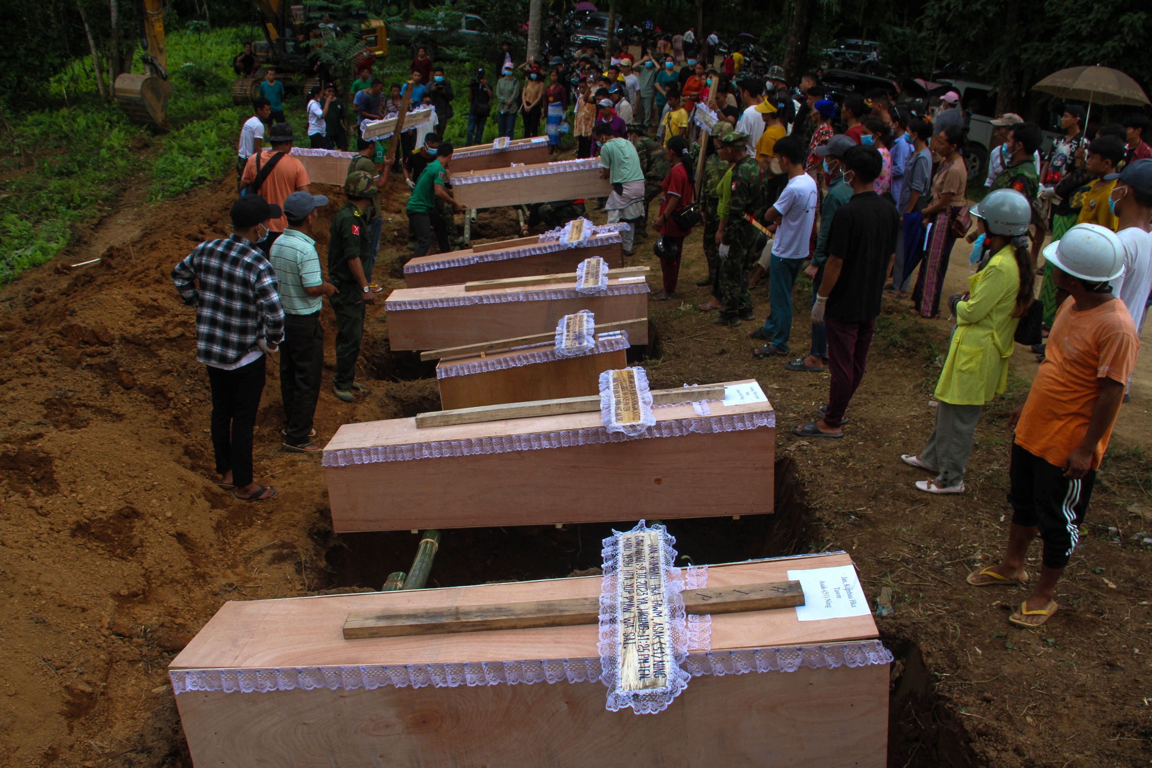Coffins lined up beside graves at a mass funeral for victims of a Myanmar military strike on a village near Laiza, Myanmar, October 10, 2023.