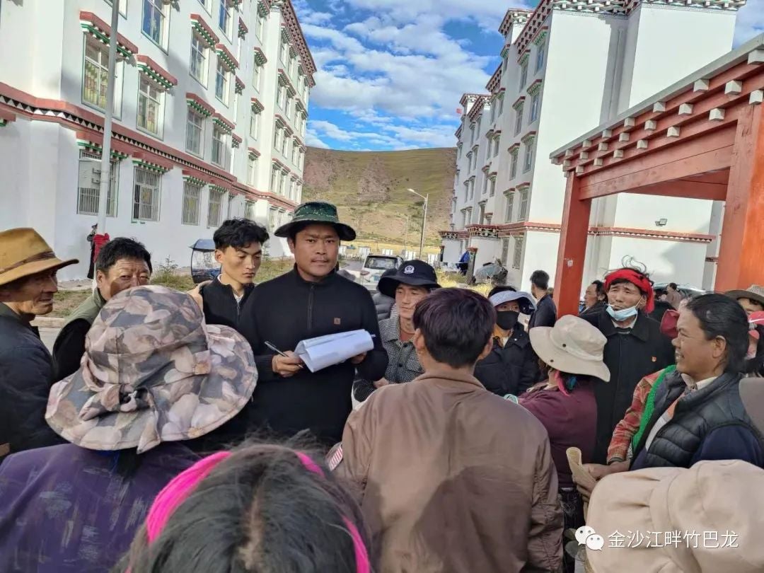 A group gathers around an official taking notes on a clipboard