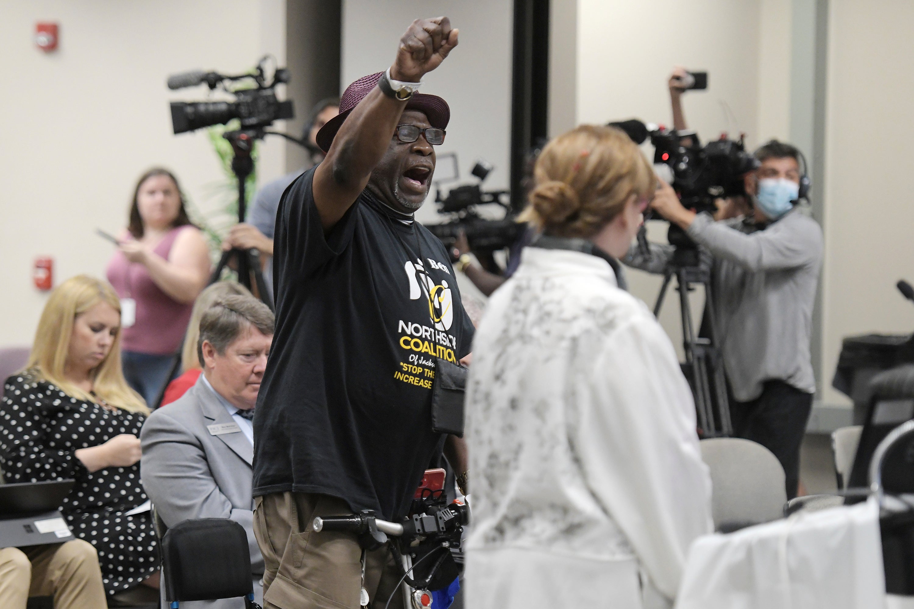 A man stands up and chants during a meeting