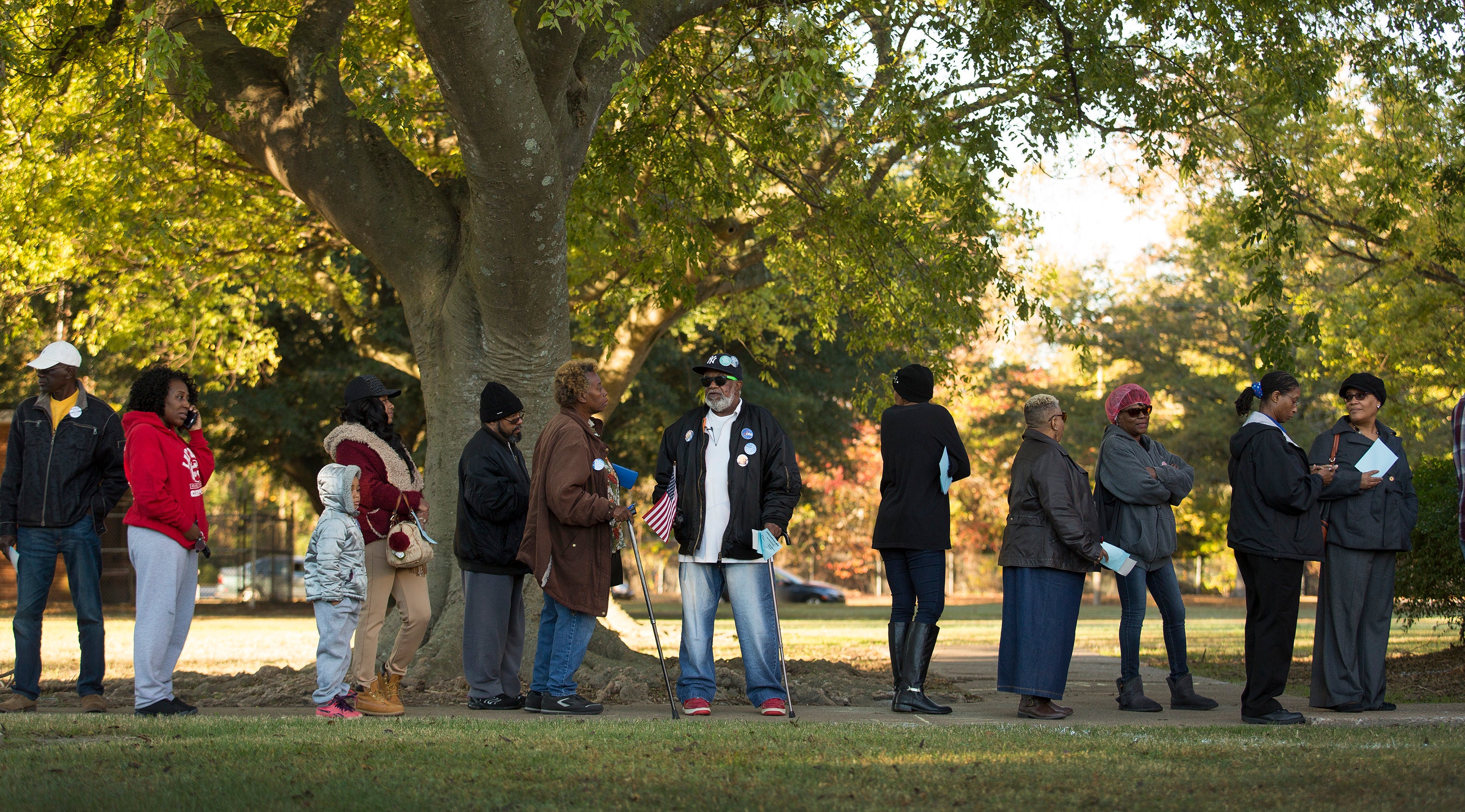 Bernard Smith Jr., 78 ans (centre de la photo) faisait la queue avec d'autres citoyens américains à Norfolk, en Virginie, pour voter lors de l’élection présidentielle tenue le 8 novembre 2016. Smith avait été précédemment privé du droit de vote en raison d’une condamnation antérieure pour un crime, mais ce droit a été rétabli dans son cas, lui permettant de participer à ce vote. © 2016 Bill Tiernan/The Virginian-Pilot via AP