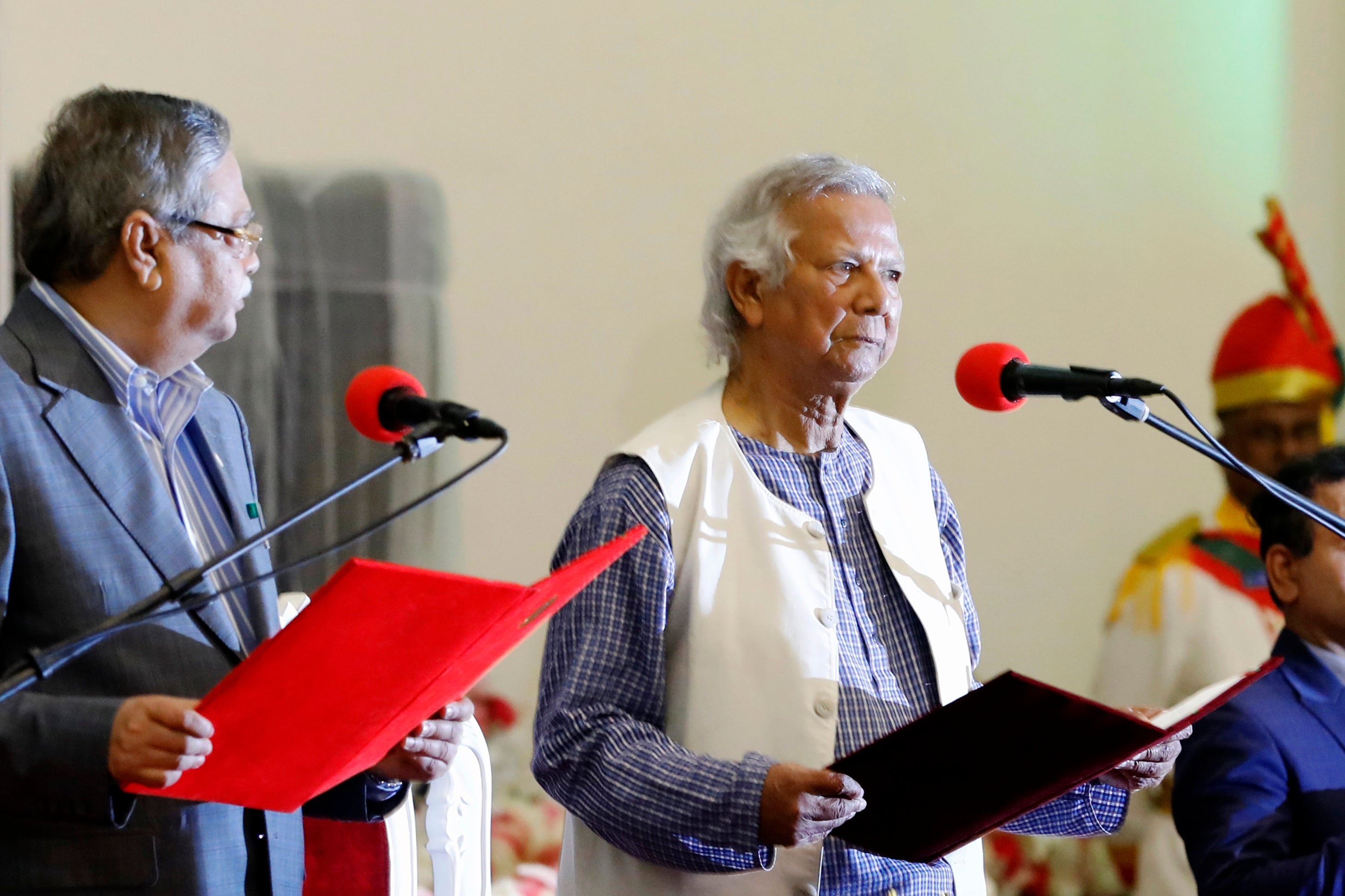Nobel laureate Muhammad Yunus, right, takes the oath of office as the head of Bangladesh's interim government in Dhaka, Bangladesh, August 8, 2024.
