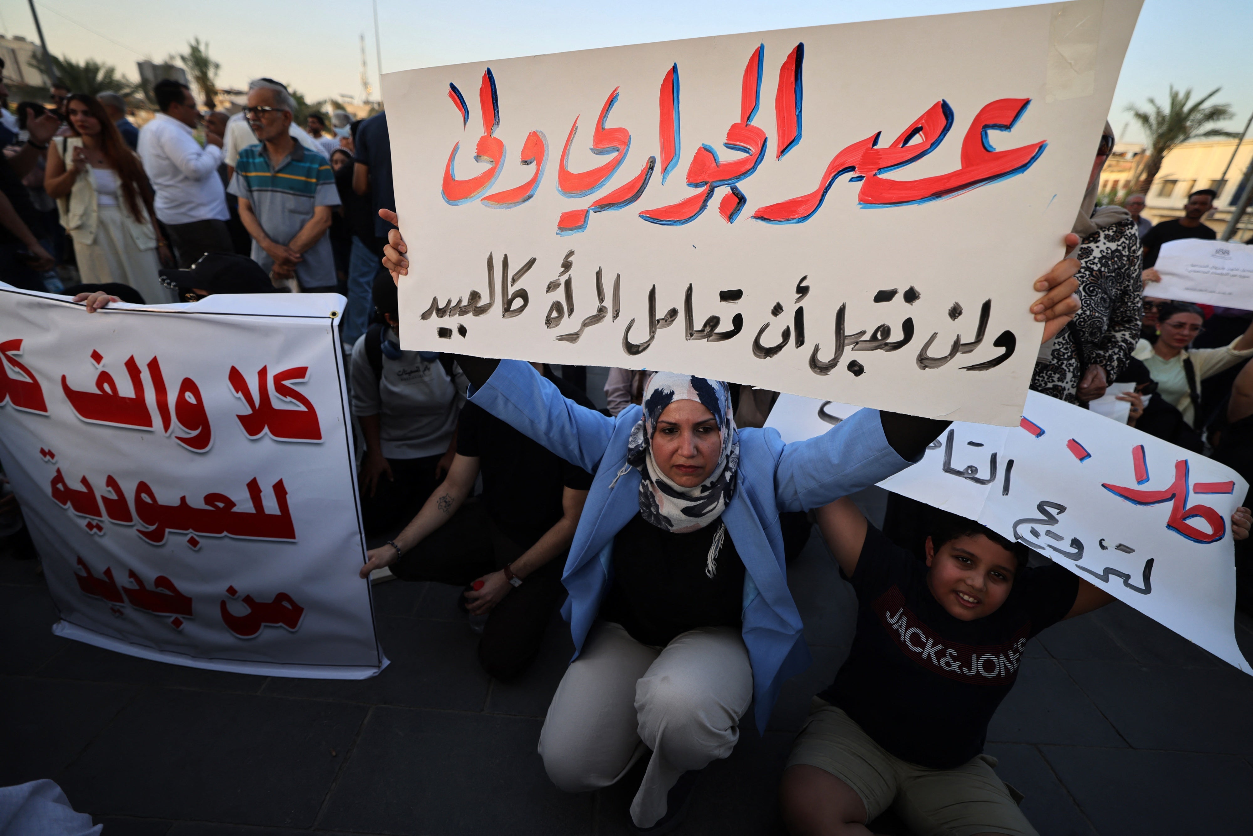 A woman holds a sign protesting women being deprived of their rights in marriage in Tahrir Square, Baghdad, Iraq, August 8, 2024.