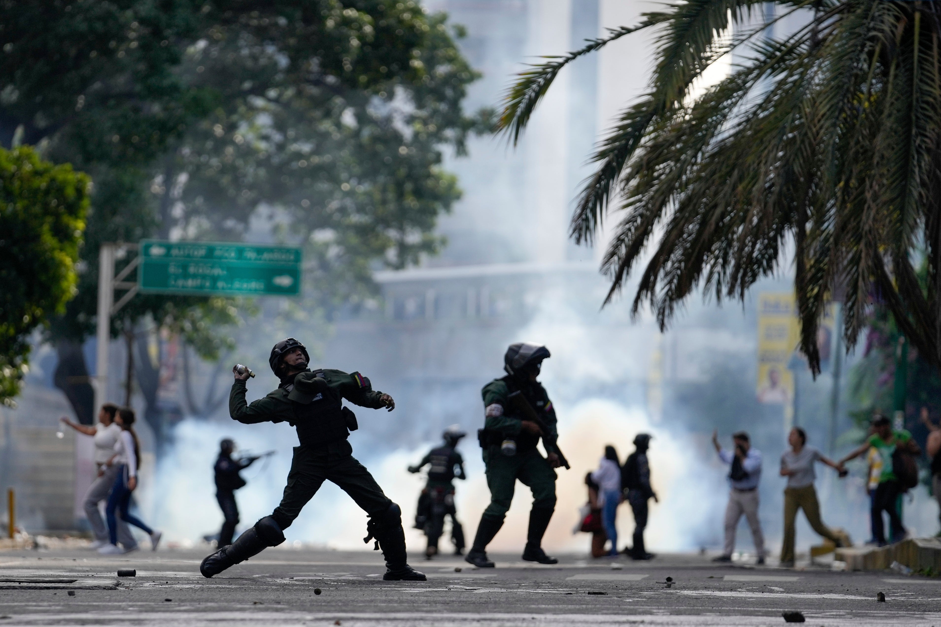 Un policier s’apprêtait à lancer une grenade lacrymogène sur des manifestants à Caracas, au Venezuela, le 29 juillet 2024, au lendemain de l’élection présidentielle ; les manifestants protestaient contre l'annonce des résultats, selon lesquels Nicolás Maduro aurait été réélu, malgré les signes flagrants d’irrégularités électorales.