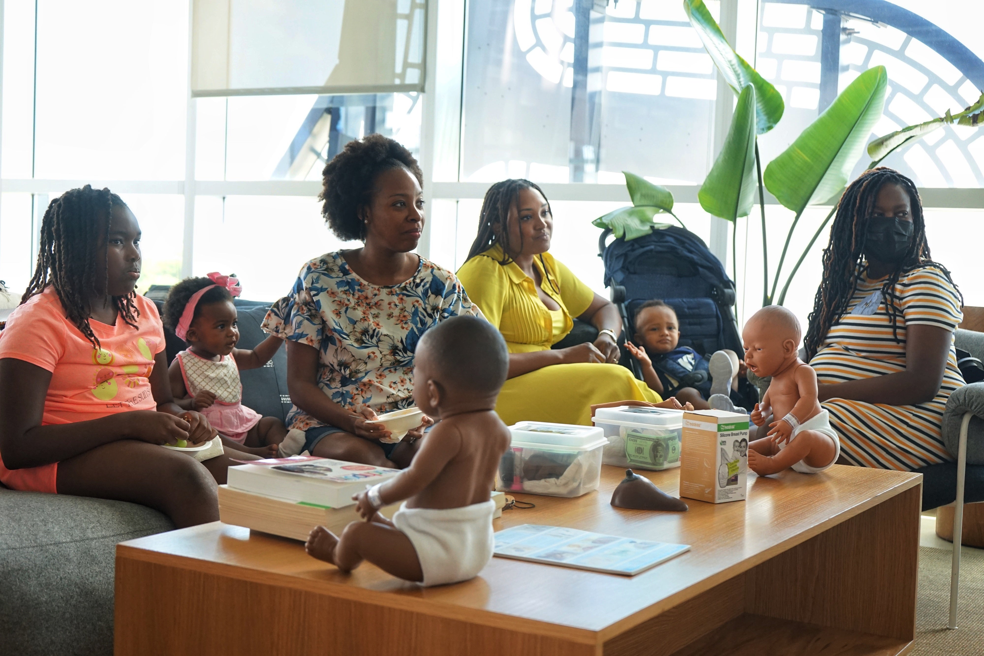A group of women and children seated at a workshop