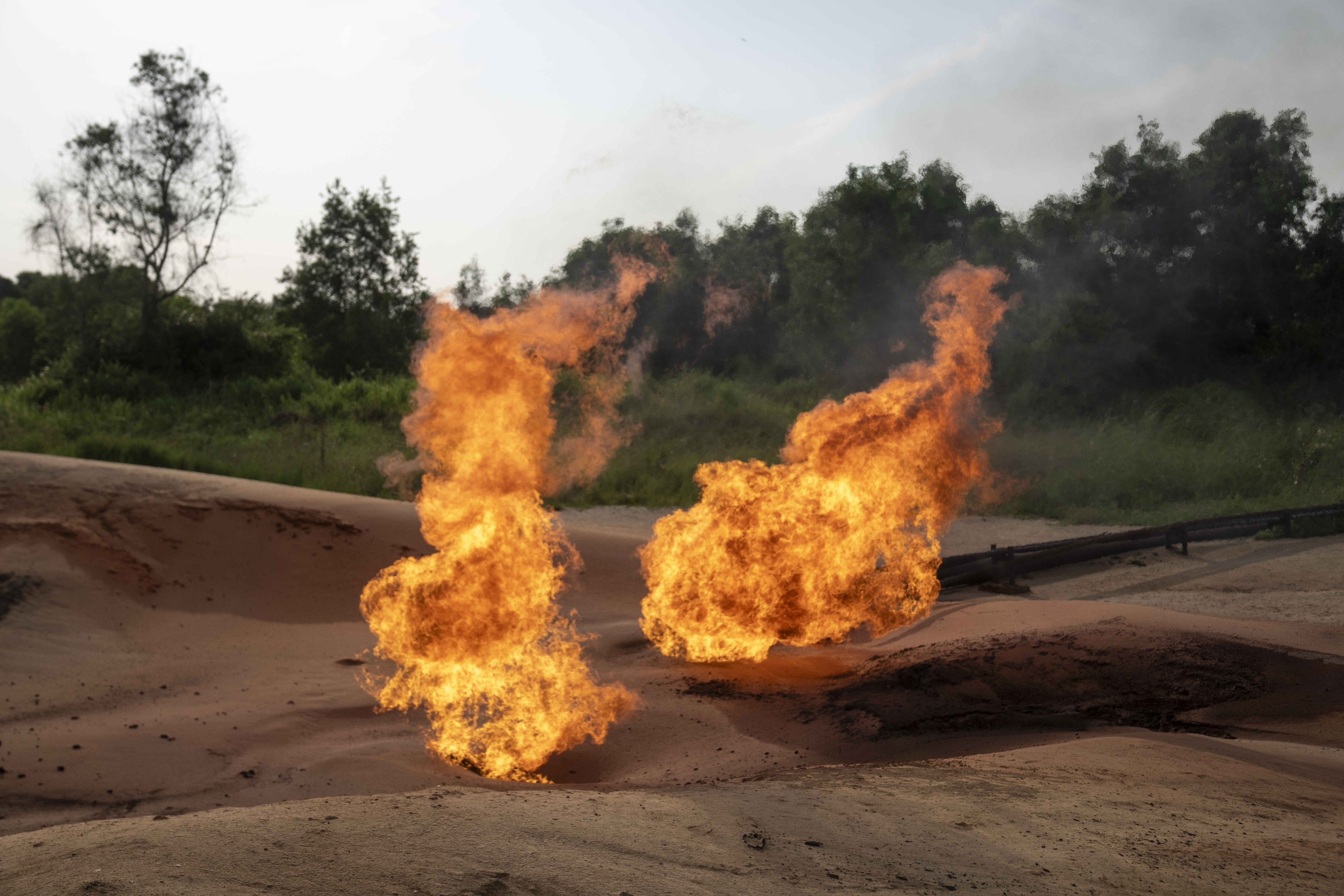 Deux torches de brûlage de gaz excédentaires, situées dans une zone d'extraction de pétrole à Moanda, en République démocratique du Congo, photographiées le 23 décembre 2023. 