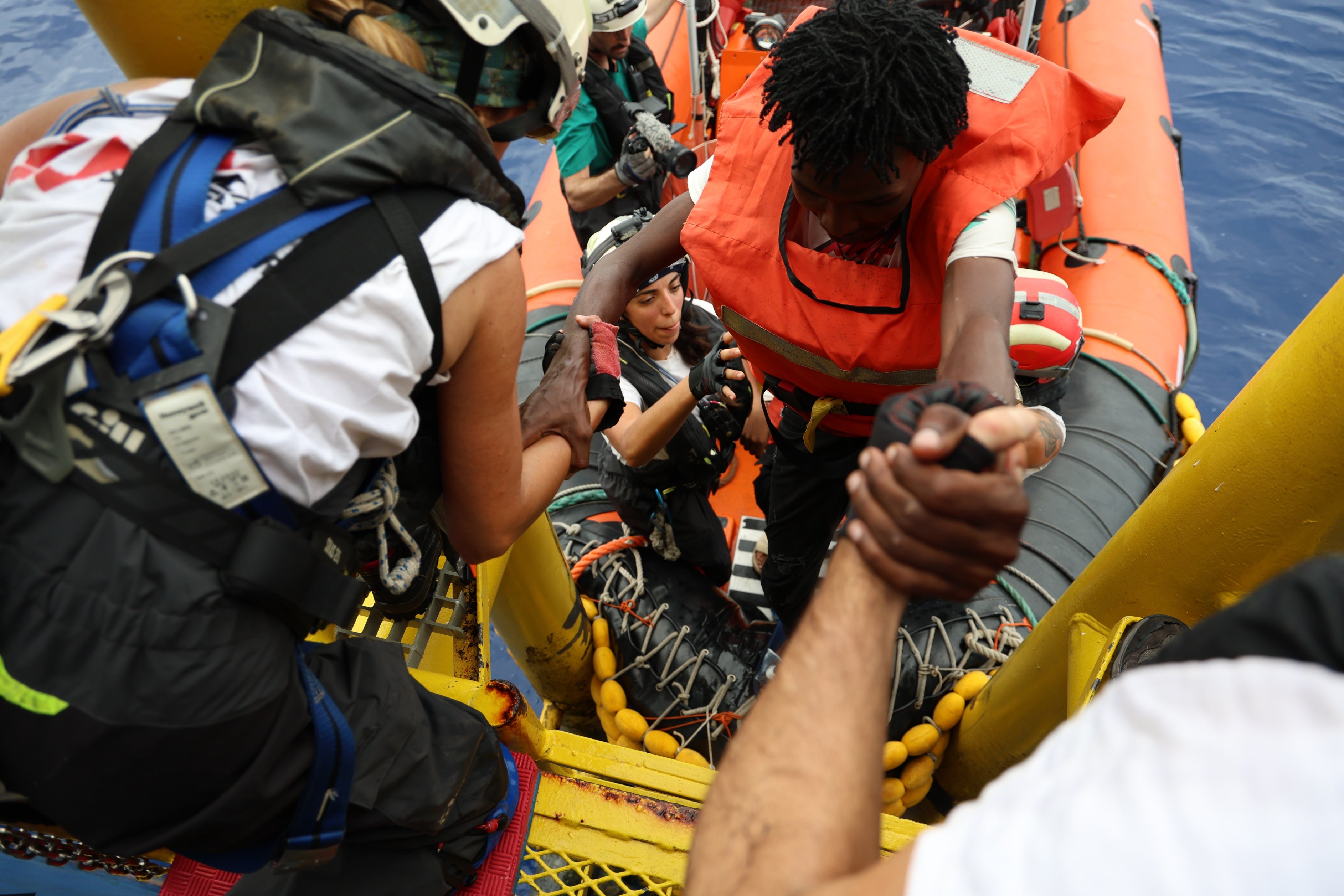 Médécins Sans Frontières rescue crew help a man on board following a rescue in the central Mediterranean Sea, September 20, 2024. 