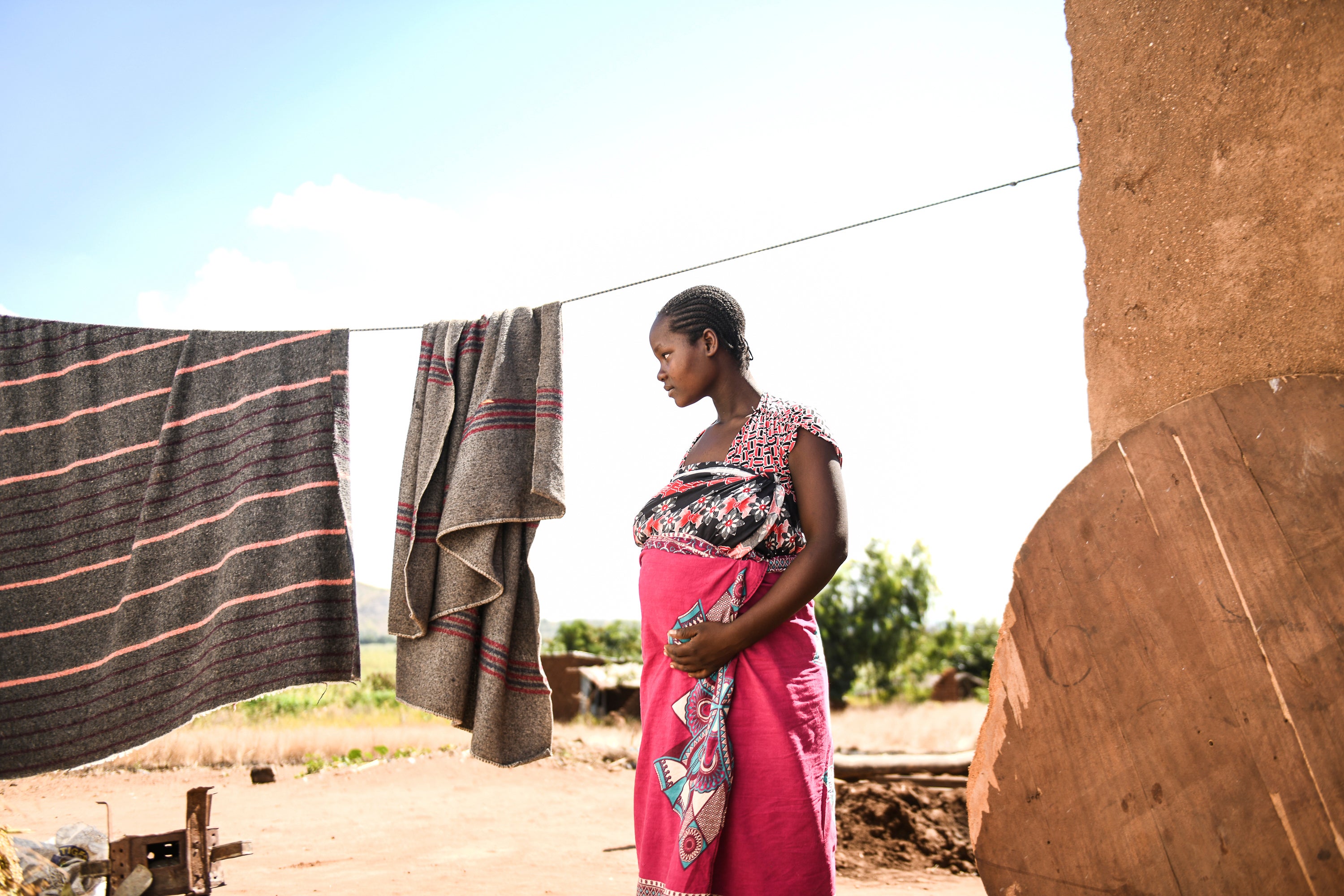 A pregnant woman waits to see a traditional birth attendant at her home in Simika Village, Chiradzulu, southern Malawi, 2021.