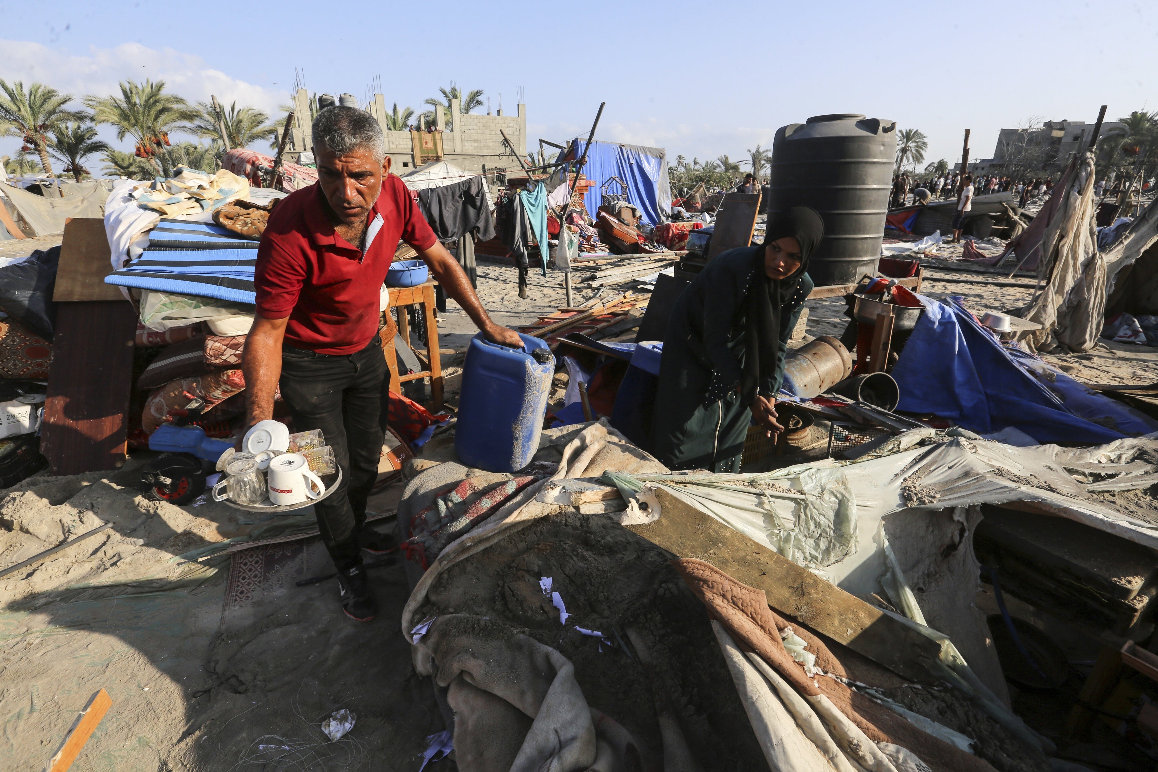 Palestinians inspect the site following Israeli strikes on a tent camp 