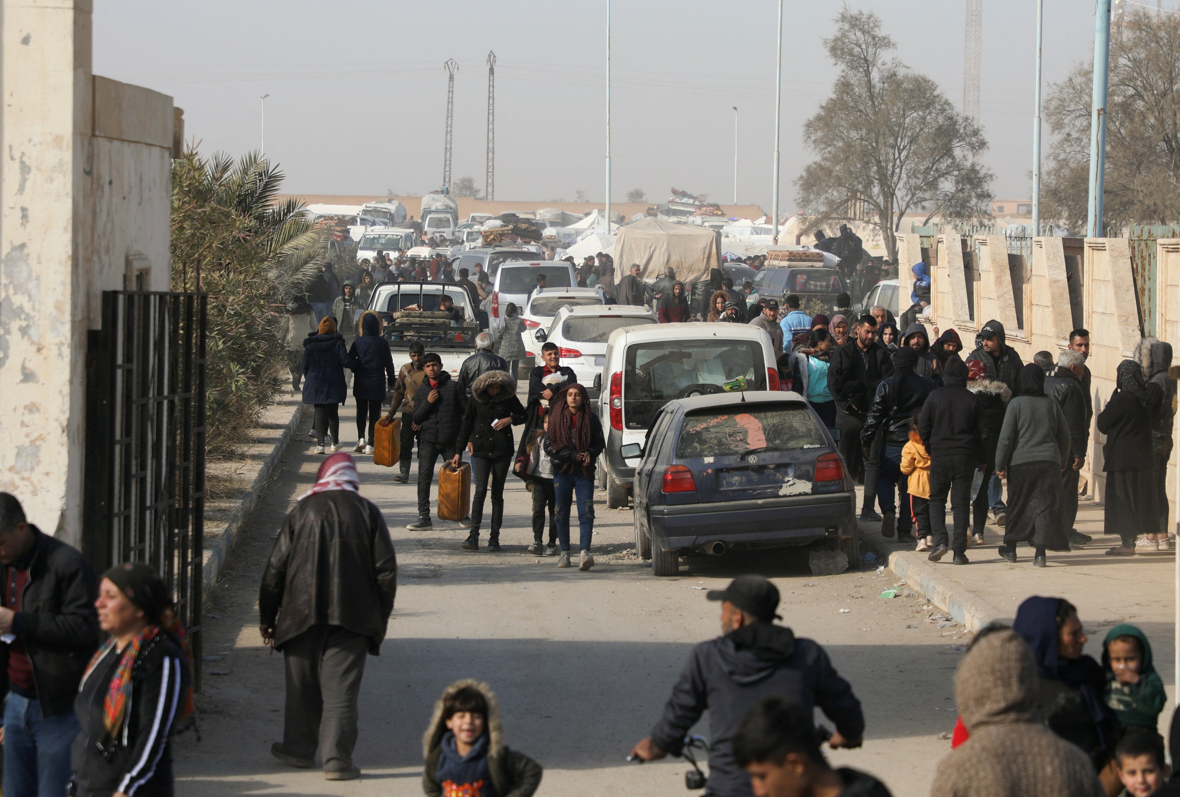 Displaced people who fled the Aleppo countryside walk in Tabqa, Syria, December 4, 2024. 