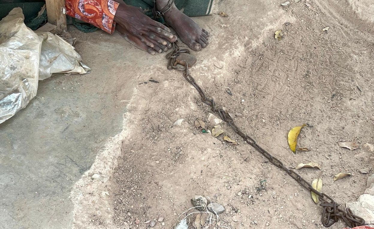 A young man chained to a tree in a shed in a Christian healing center in Ibadan, Nigeria.