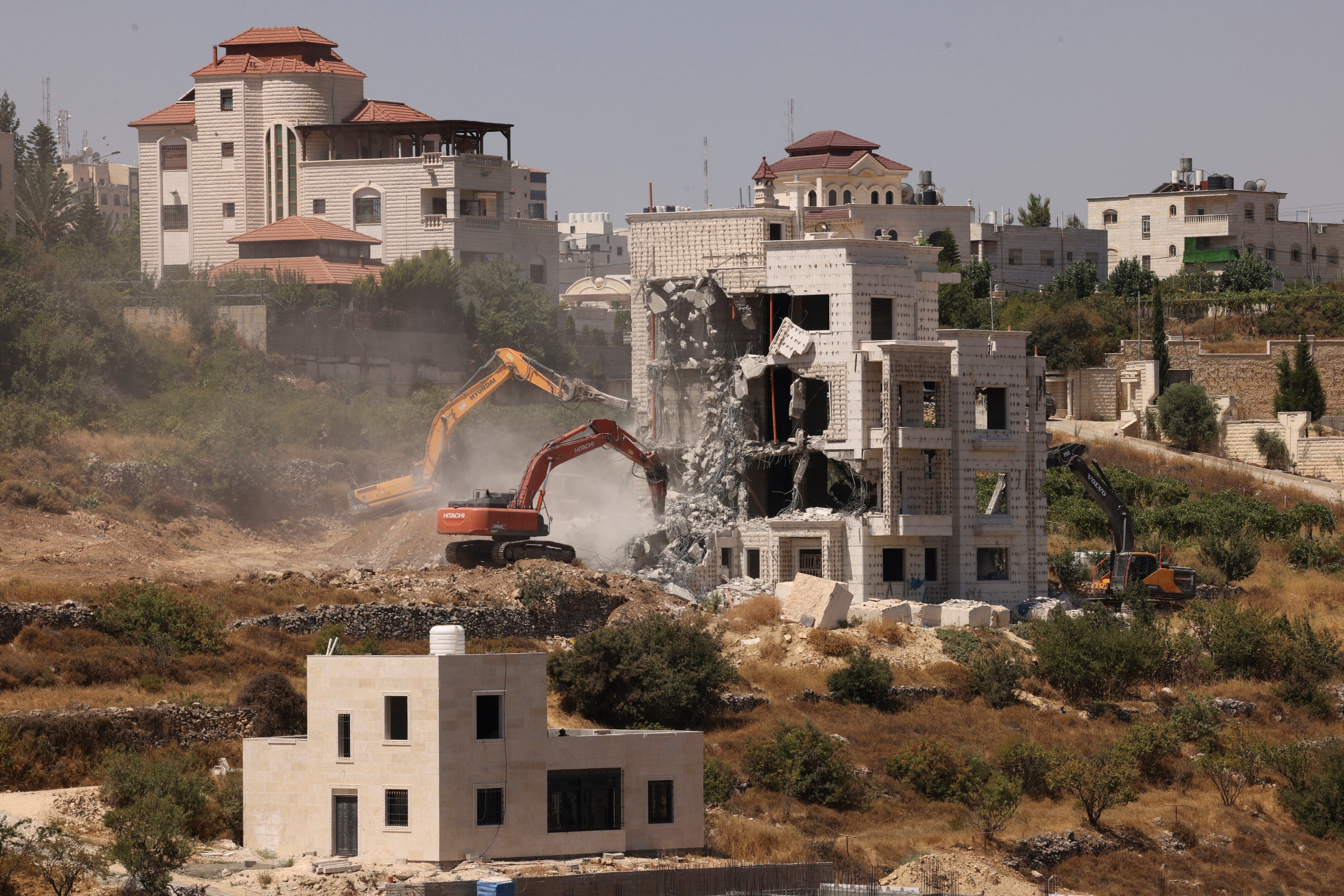 Le autorità israeliane demoliscono una casa palestinese in costruzione nella città di Hebron, nella Cisgiordania occupata da Israele. 25 luglio 2024. © 2024 Hazem Bader/AFP tramite Getty Images