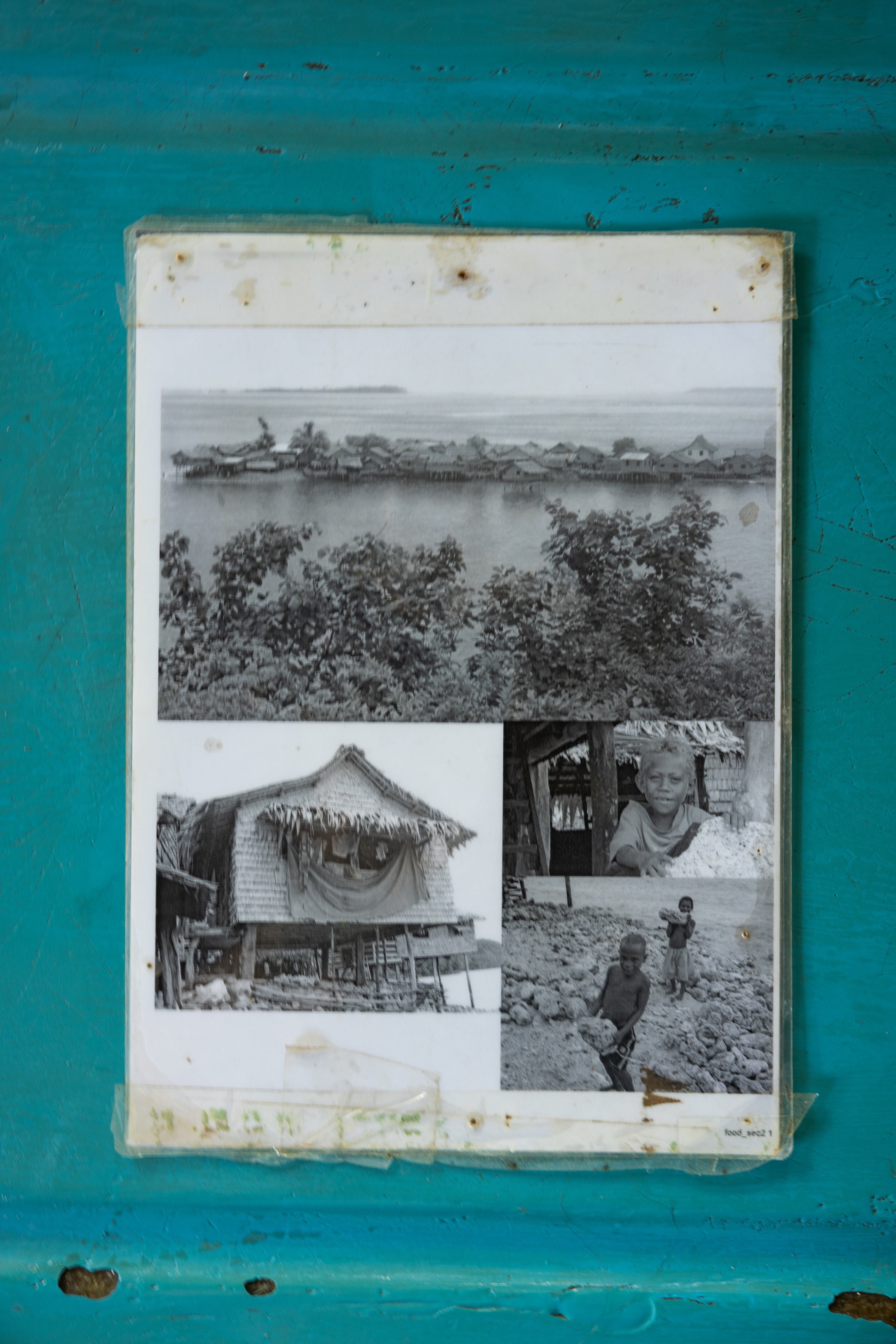 Photographs of their former island home in community archives, Walande.