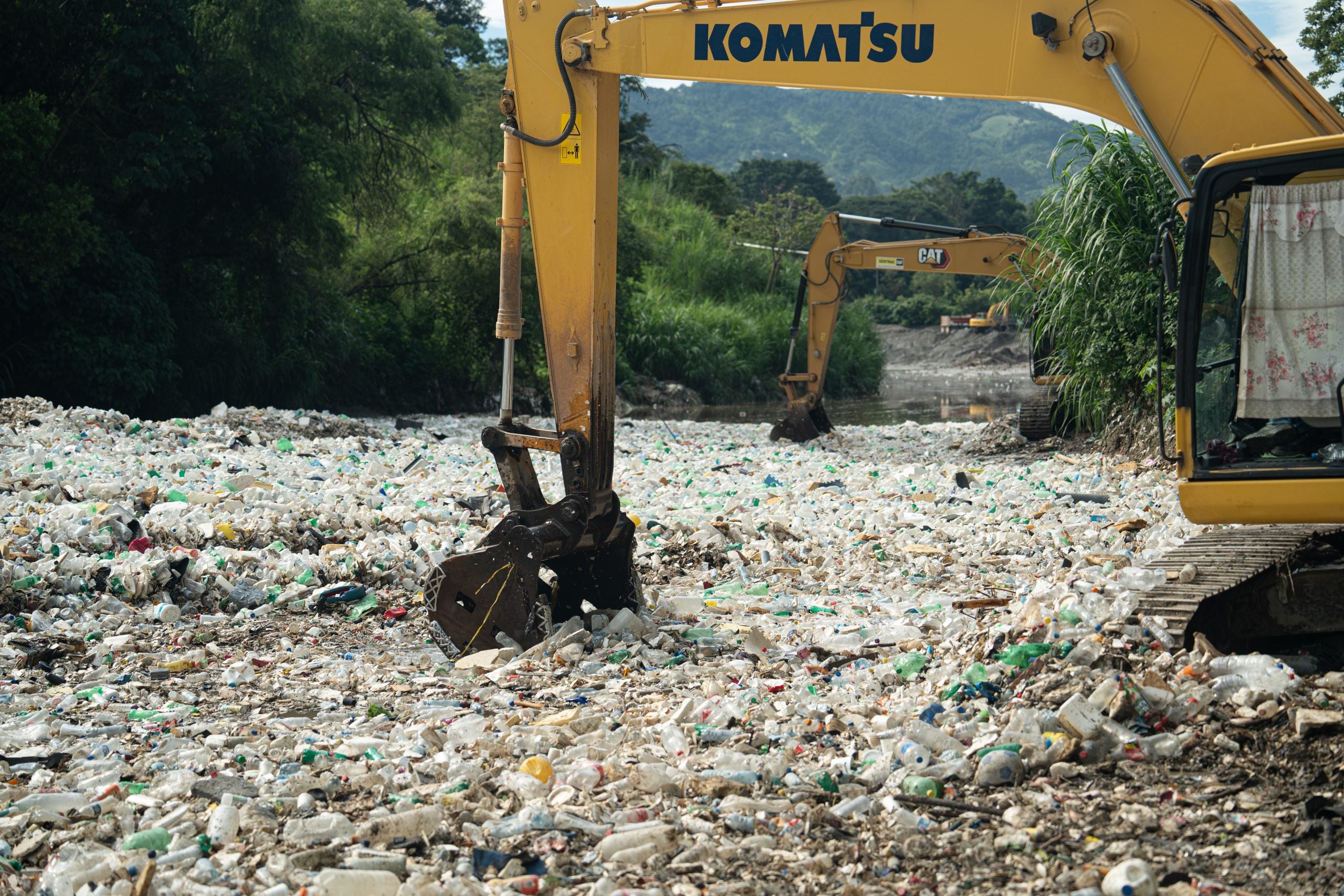 Excavators remove trash from Las Vacas River near Guatemala City, collected by a barricade built by the NGO the Ocean Cleanup. 