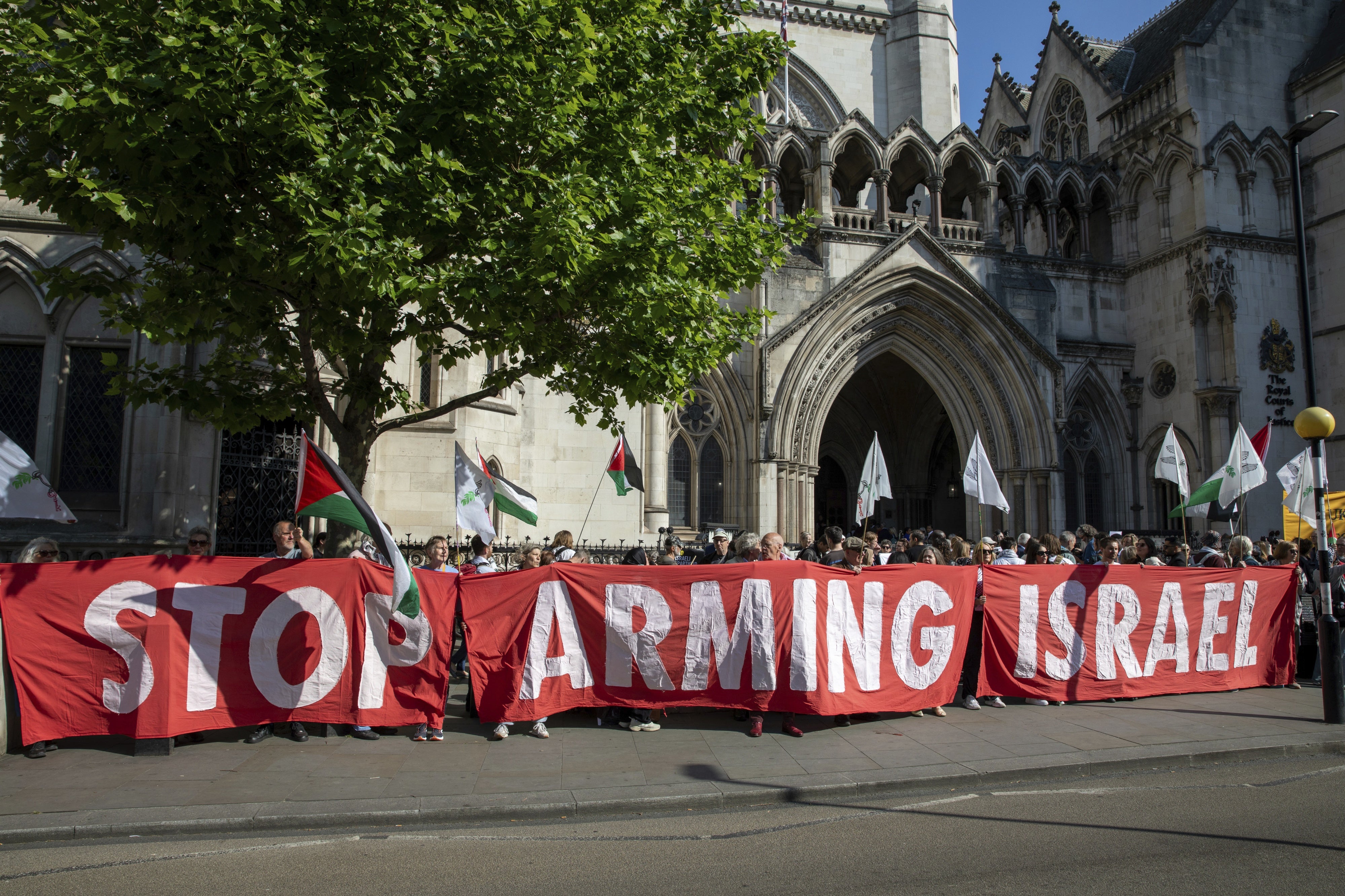Des militants brandissent une banderole lors d'une manifestation devant le palais de justice de Londres, au Royaume-Uni, le 13 mai 2025.
