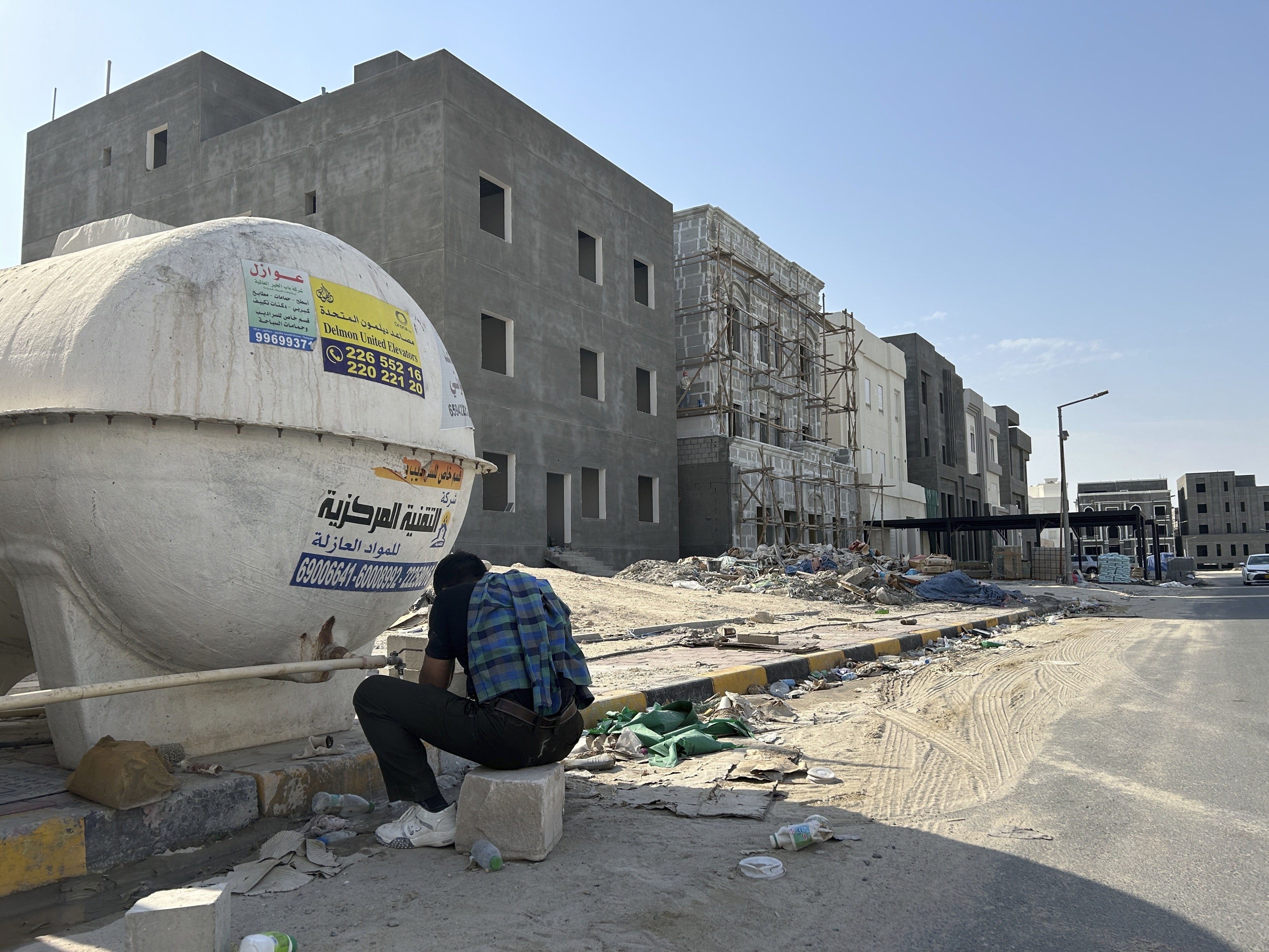 A construction worker washes his hands and face at the end of his working shift in Al Farwaniyah, Kuwait, August 8, 2024. 