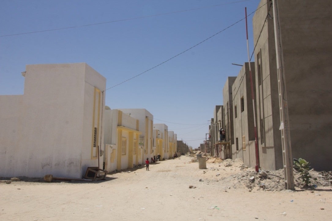 Completed (left) and under-construction (right) houses in the Djougop relocation site, April 2025. 