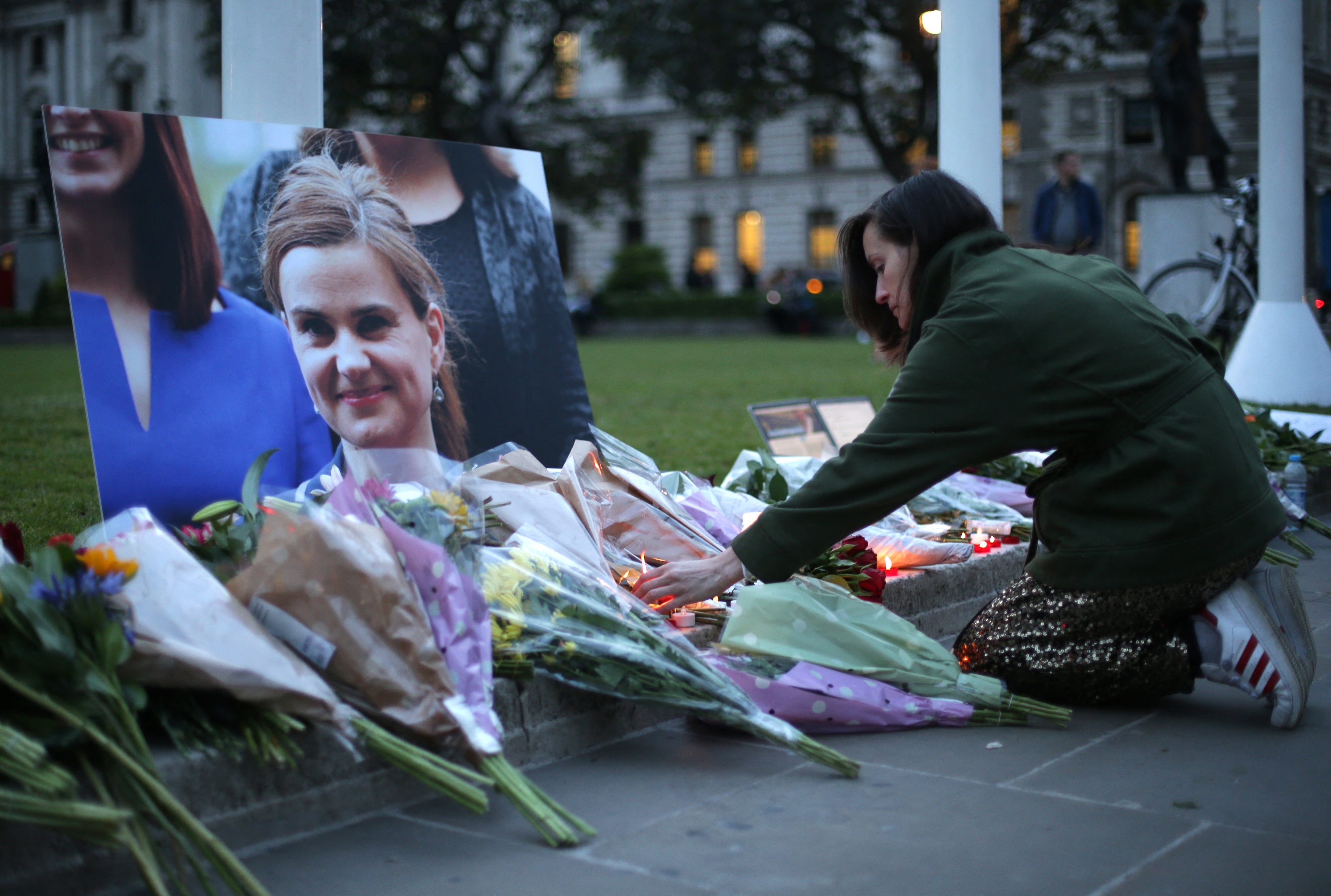 Floral tributes and candles are placed by a picture of slain Labour MP Jo Cox at a vigil in Parliament square in London on June 16, 2016.