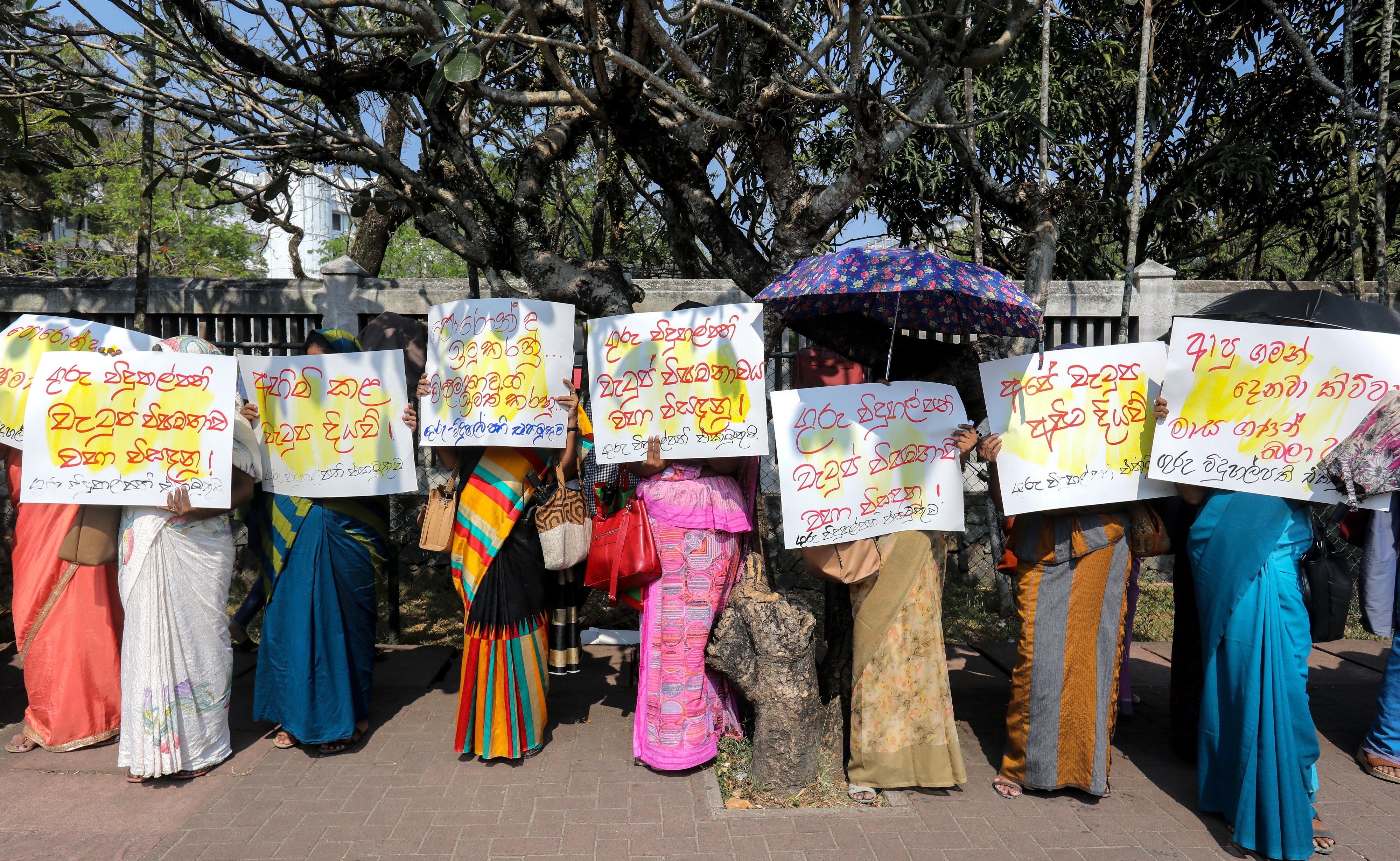 People hold placards at a protest
