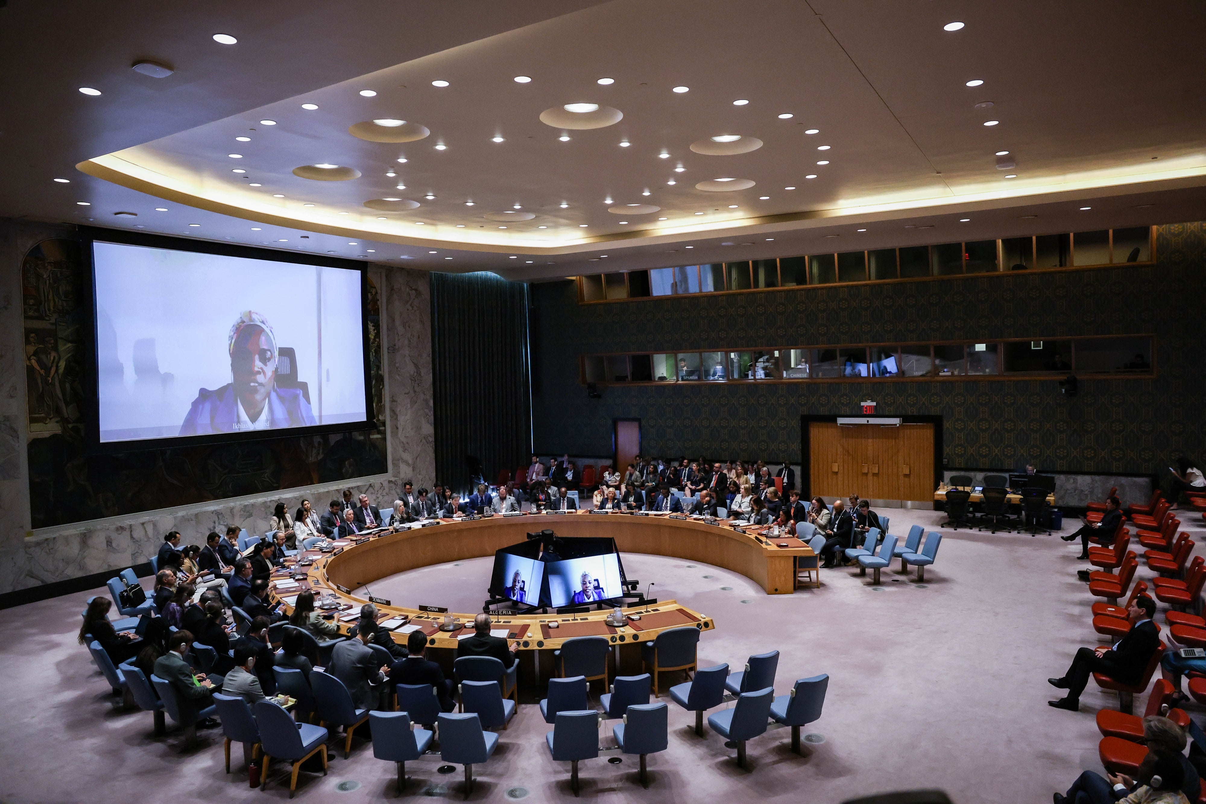  Iklass Ahmed, projected on screen, Founder and Coordinator of the Darfur Advocacy Group, addresses the Security Council during a meeting on Women, Peace and Security focused on conflict-related sexual violence, August 19, 2025. 