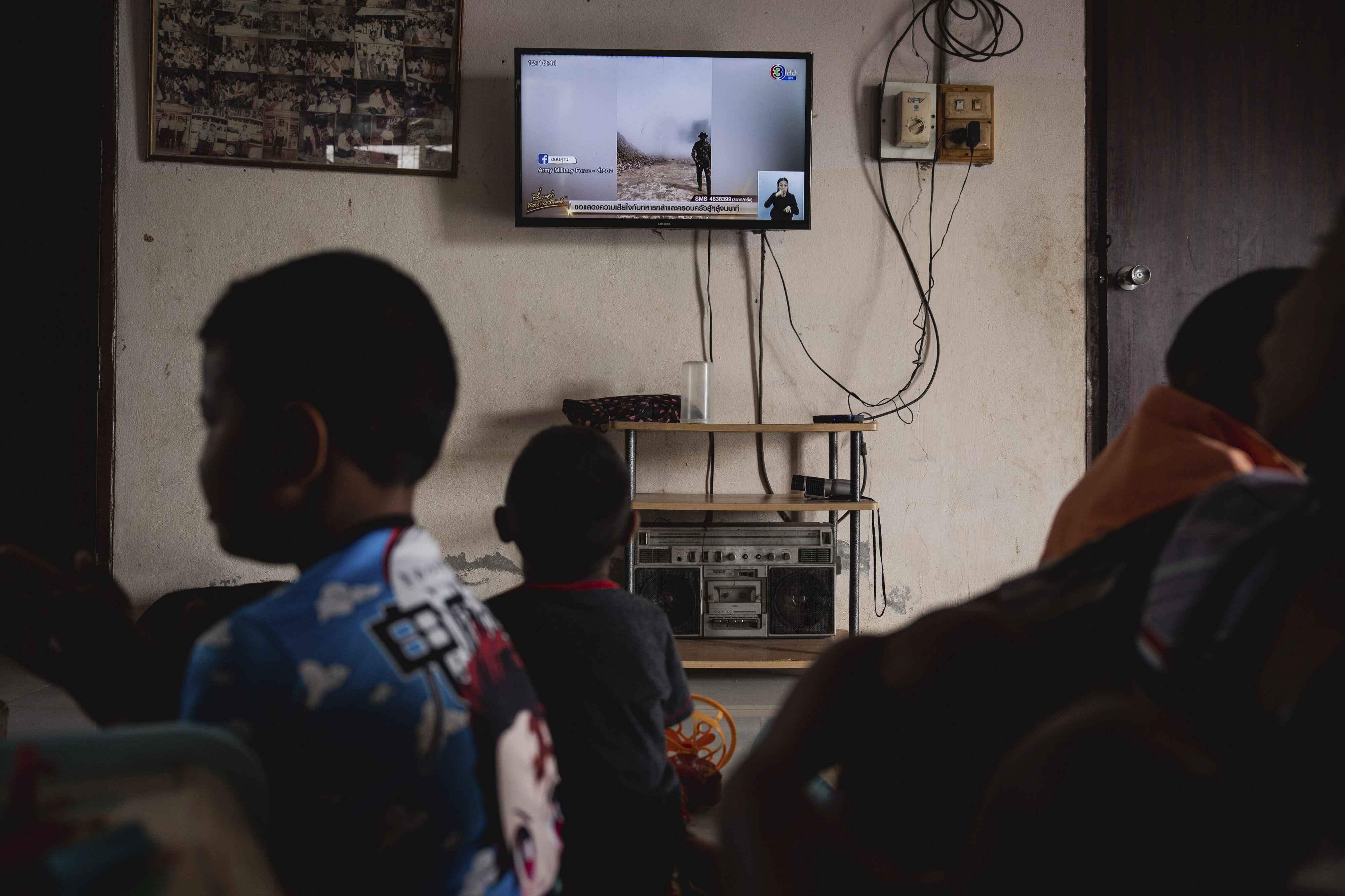 Children watch news reports about the situation along the Thai-Cambodian border, in Sisaket province in northeastern Thailand, July 27, 2025.