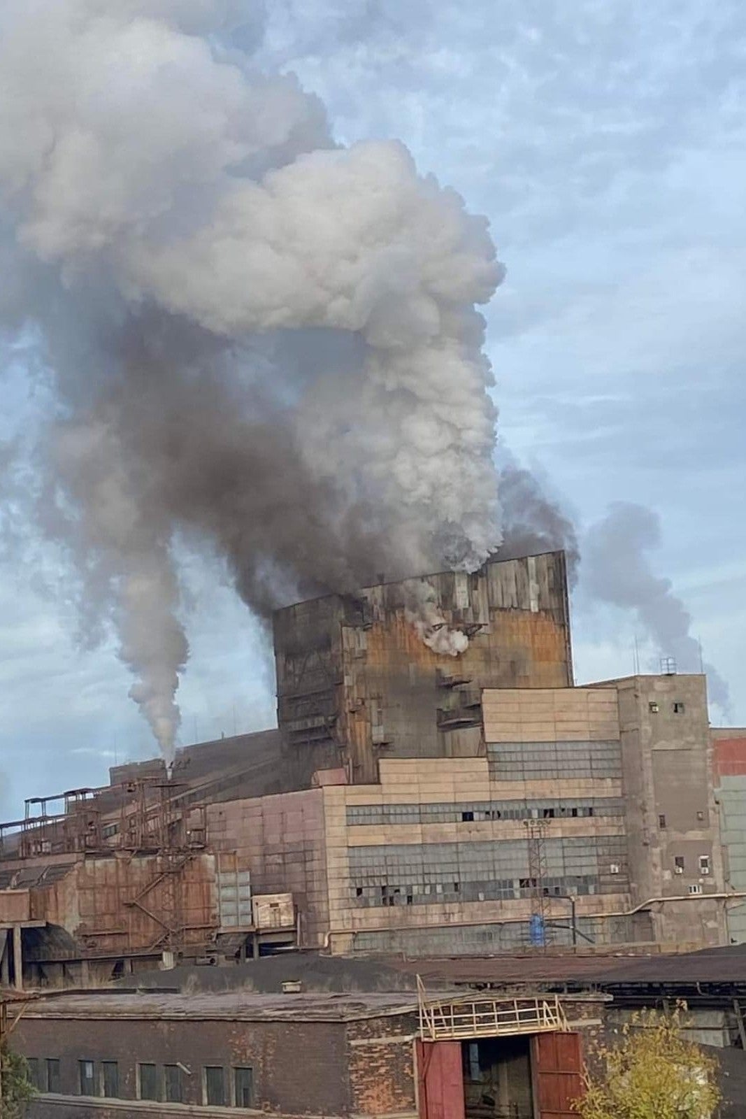 Smoke billowing from towers at a coal plant near a residential neighborhood