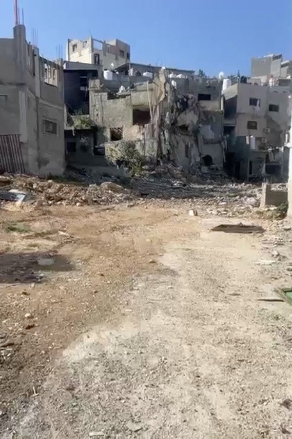 In a still from an undated video taken after the Israeli military operation in Jenin refugee camp, heavily damaged Palestinian homes and debris are seen strewn across a street