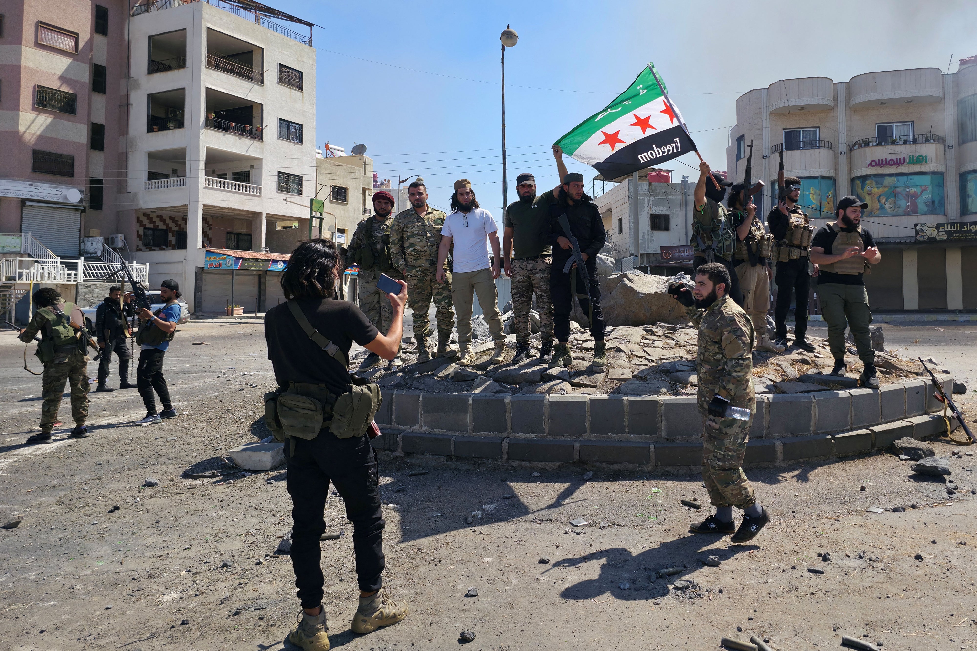 Syria's security forces pose for a picture on a roundabout in the predominantly Druze city of Sweida on July 15, 2025, following clashes between Bedouin communities and Druze fighters. Syrian government forces entered the majority Druze city of Sweida on July 15, 2025, the interior ministry said, aiming to end clashes with Bedouin communities  that have killed nearly 100 people.