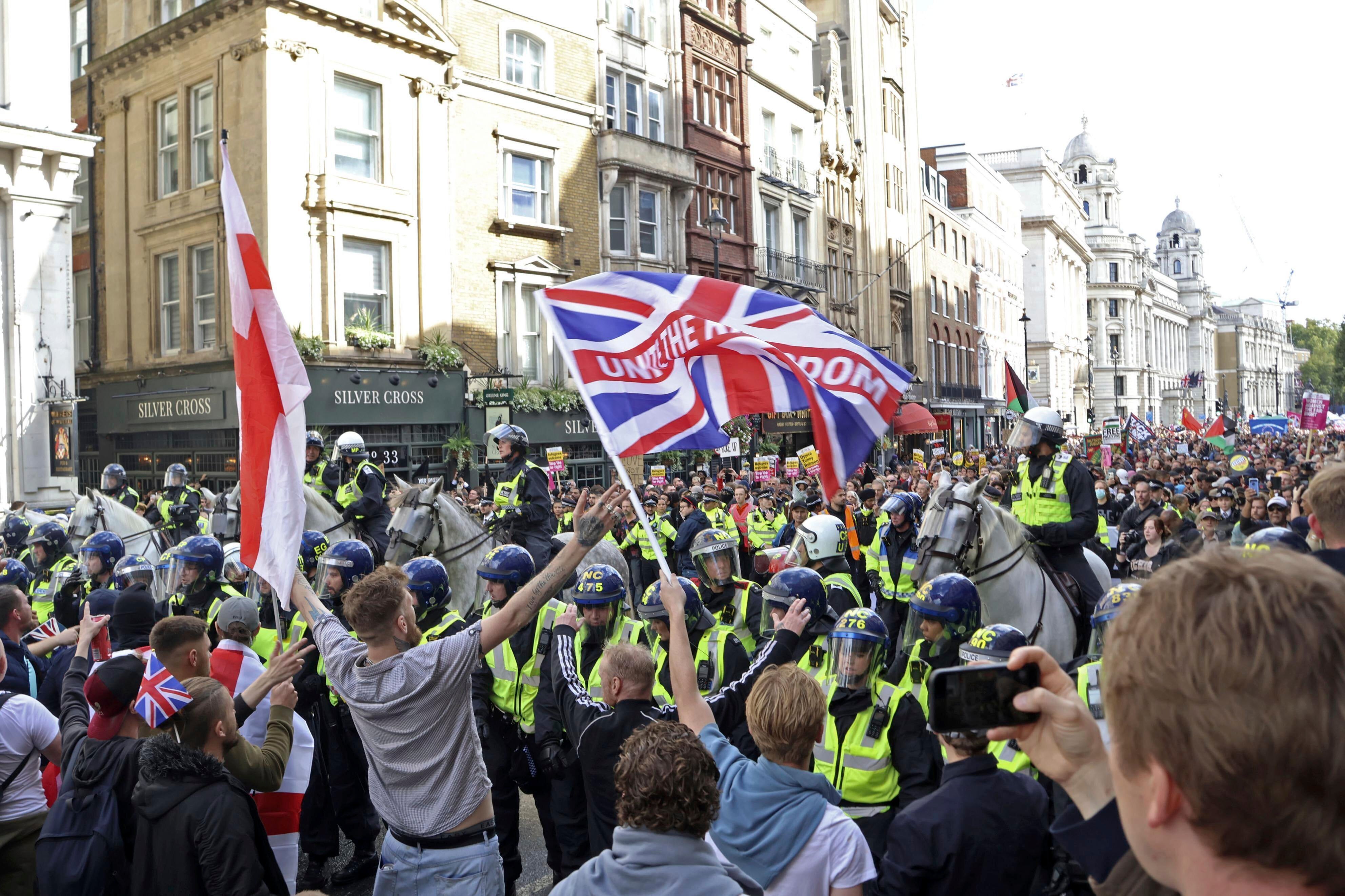 People opposing the housing of asylum seekers (front) confront anti-racism group members (back) with police officers forming a line between them in London, UK, on September 13, 2025. 
