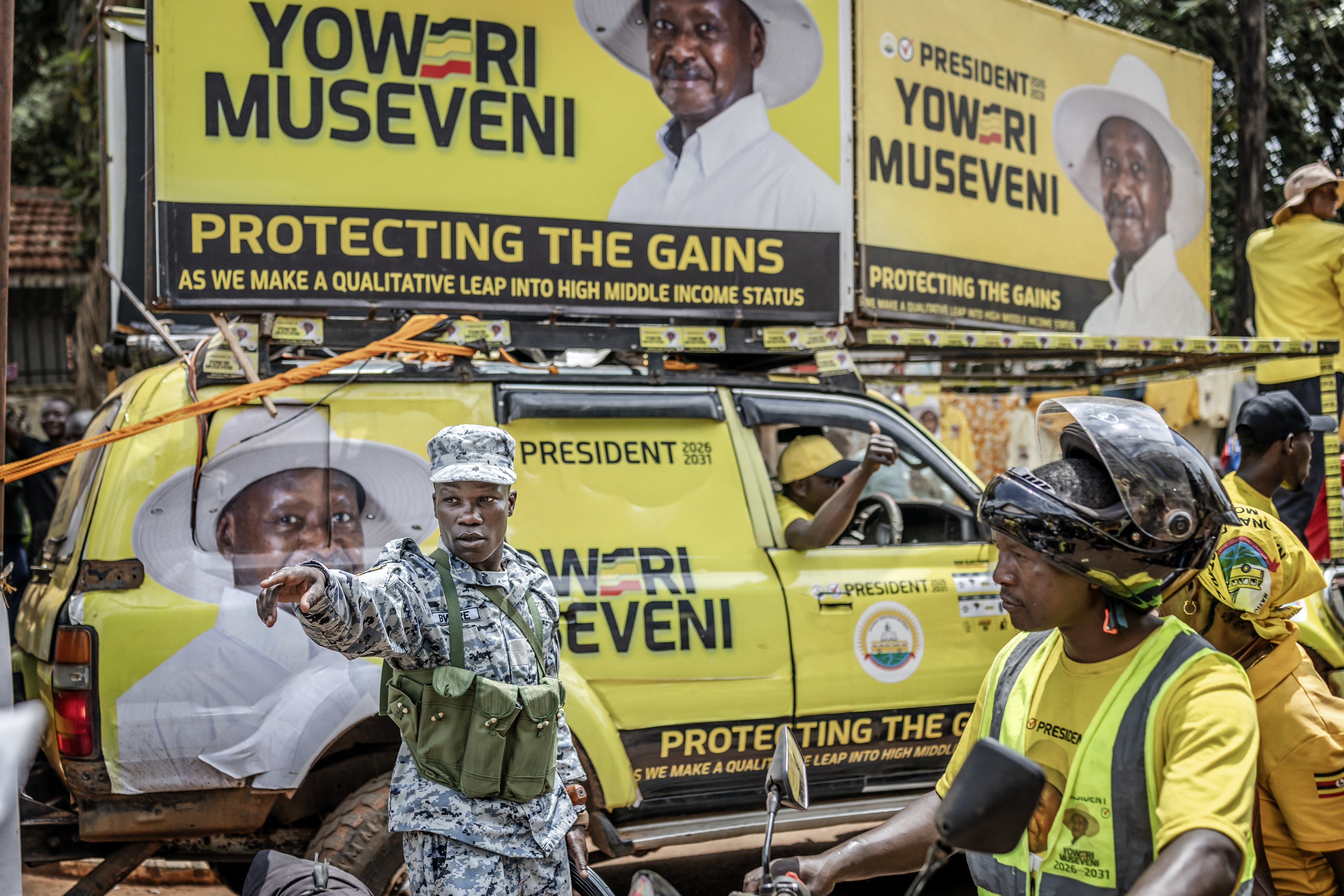 A member of the Ugandan police force gives instructions to supporters of Uganda's incumbent president and National Resistance Movement (NRM) presidential candidate Yoweri Museveni entering the rally grounds ahead of the party's closing campaign rally ahead of the 2026 Ugandan general elections, in Kampala on January 13, 2026.