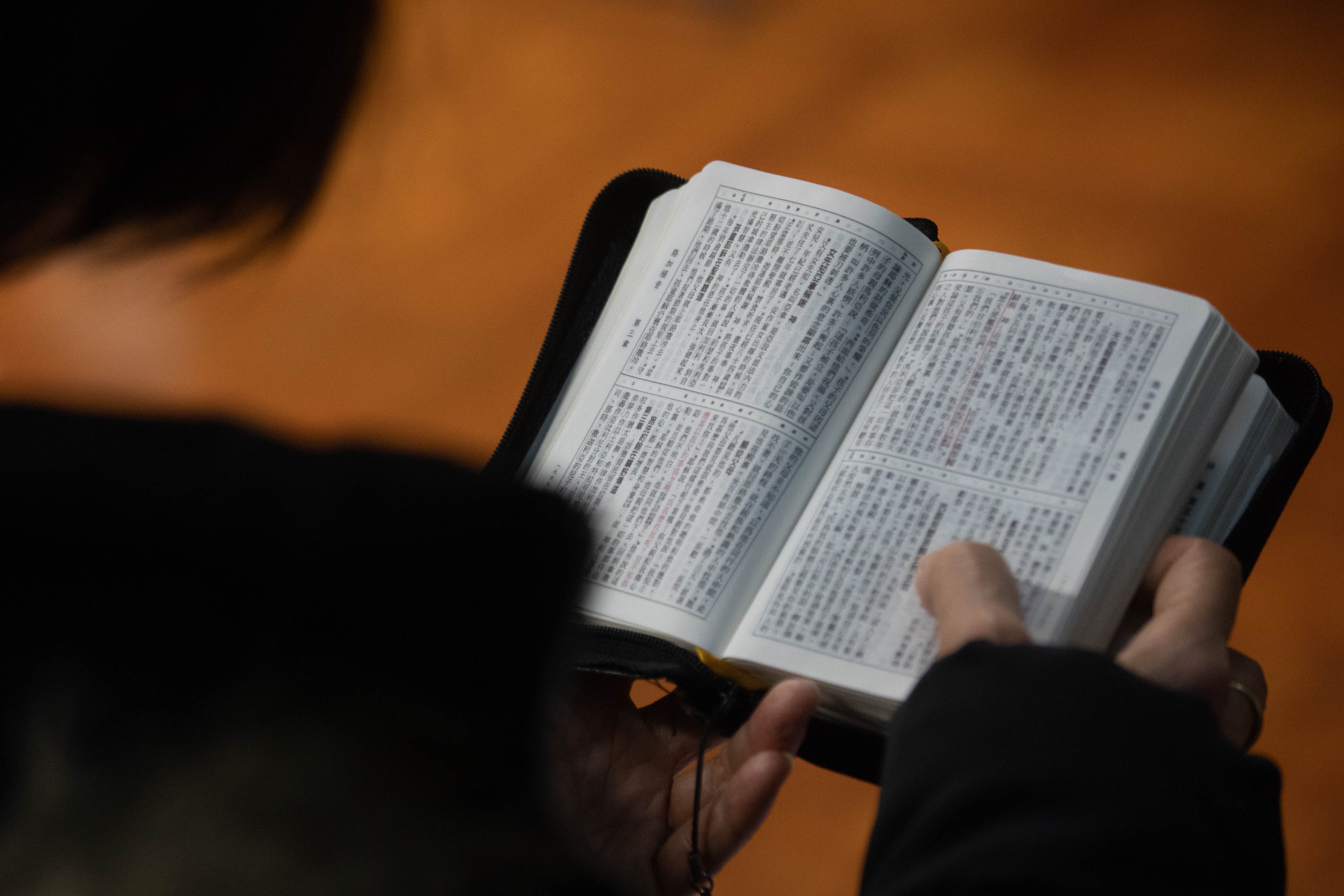 A church member reads a bible during a service in Hong Kong in solidarity with the Early Rain Covenant Church in China, whose members face persecution, December 18, 2023. 