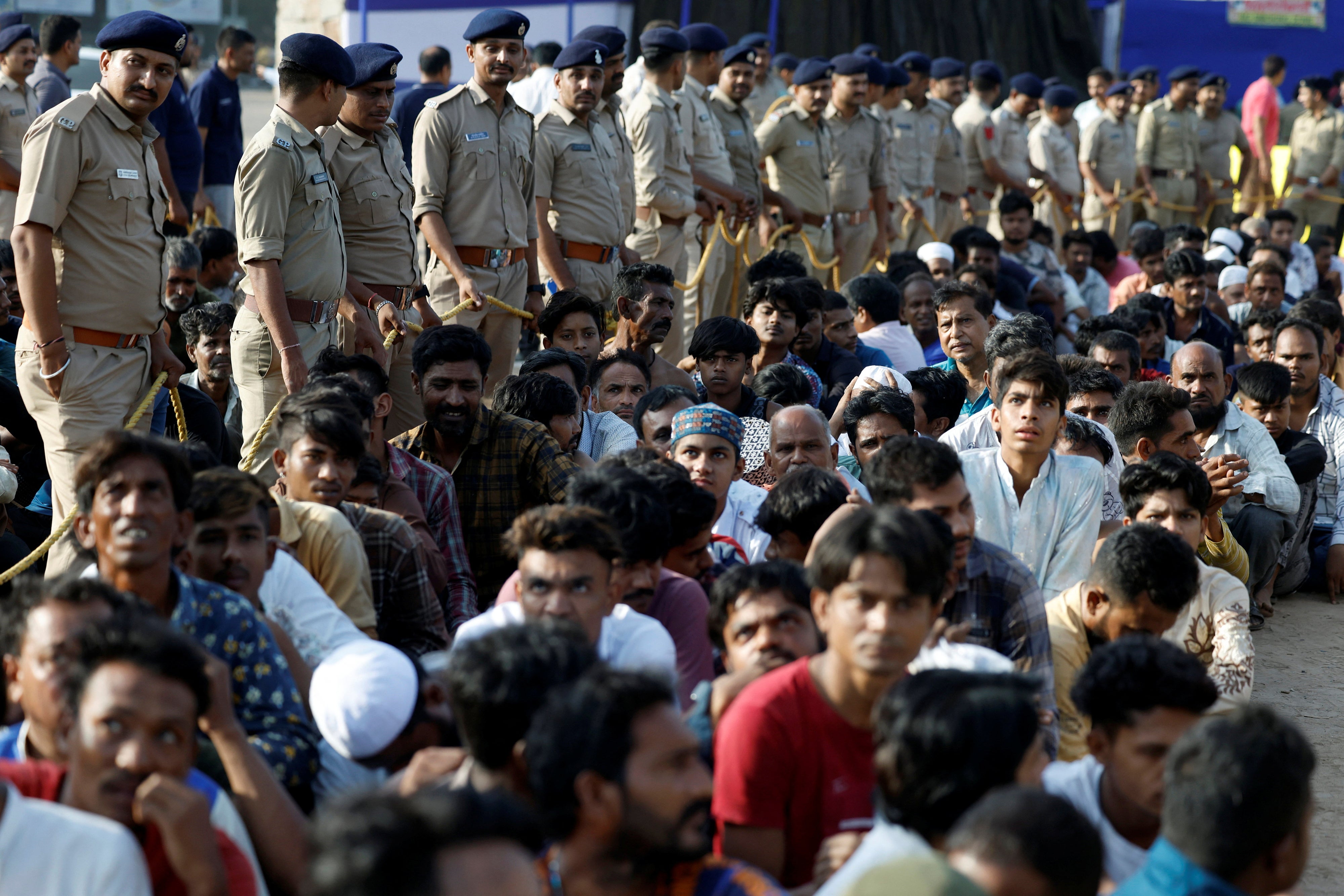 Des policiers indiens surveillaient des ressortissants bangladais présumés en situation irrégulière, arrêtés lors de descentes de police effectuées à Ahmedabad, ville située dans l'État du Gujarat, dans le nord-ouest de l'Inde. le 26 avril 2025. 