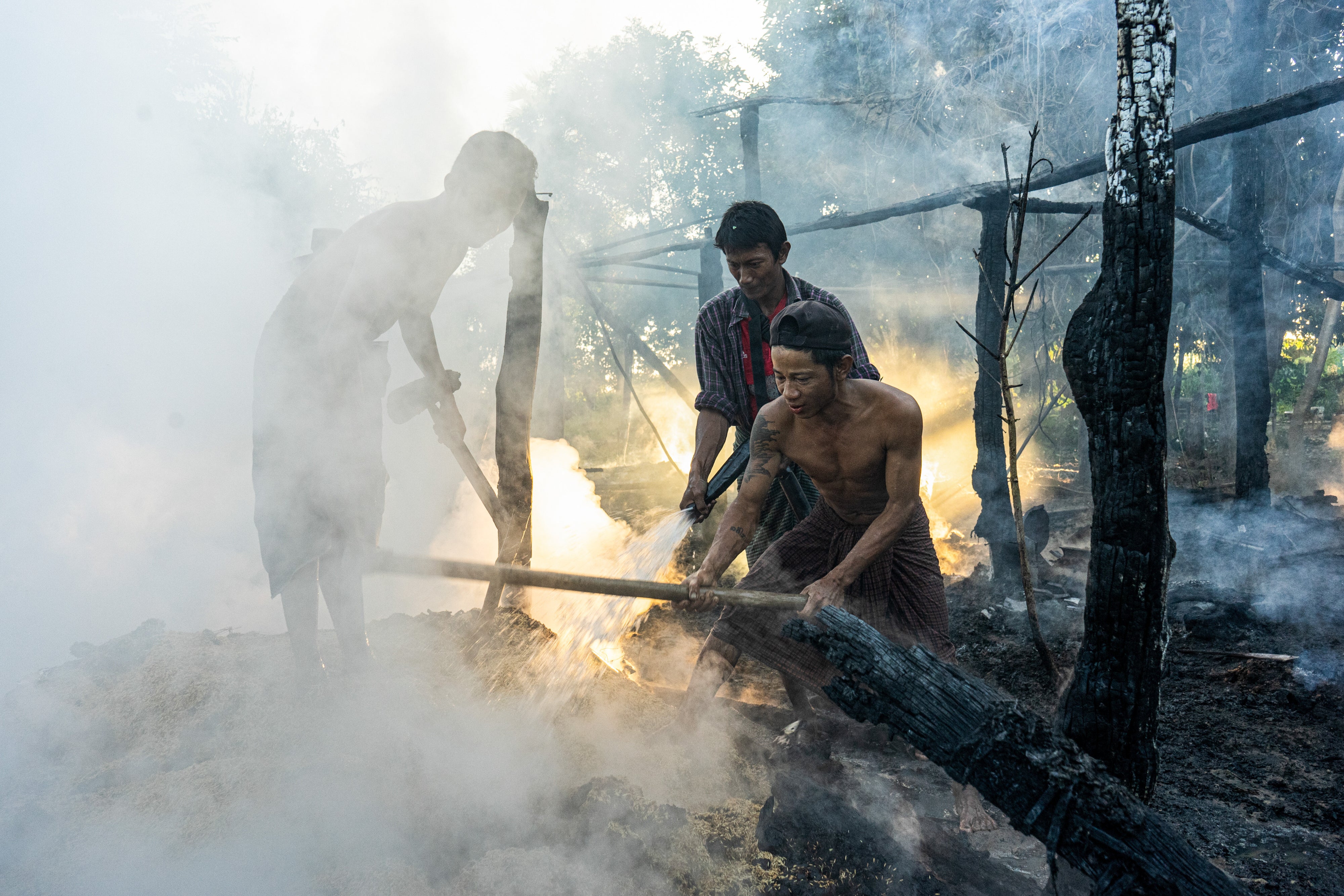 Villagers extinguish a fire that engulfed a house after a Myanmar military airstrike, Tabayin, Myanmar, November 13, 2025.