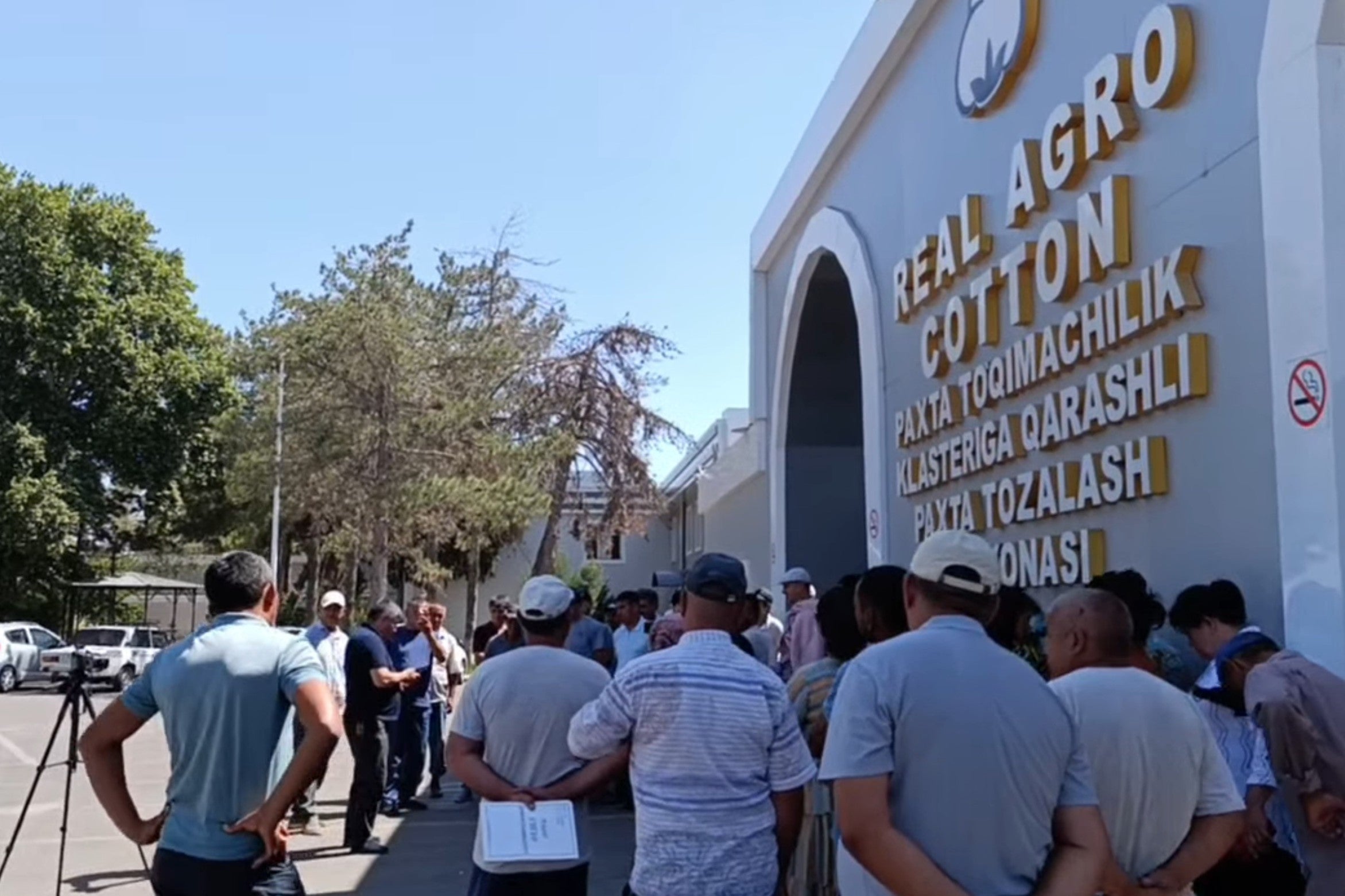 Workers gather outside a cotton cluster 